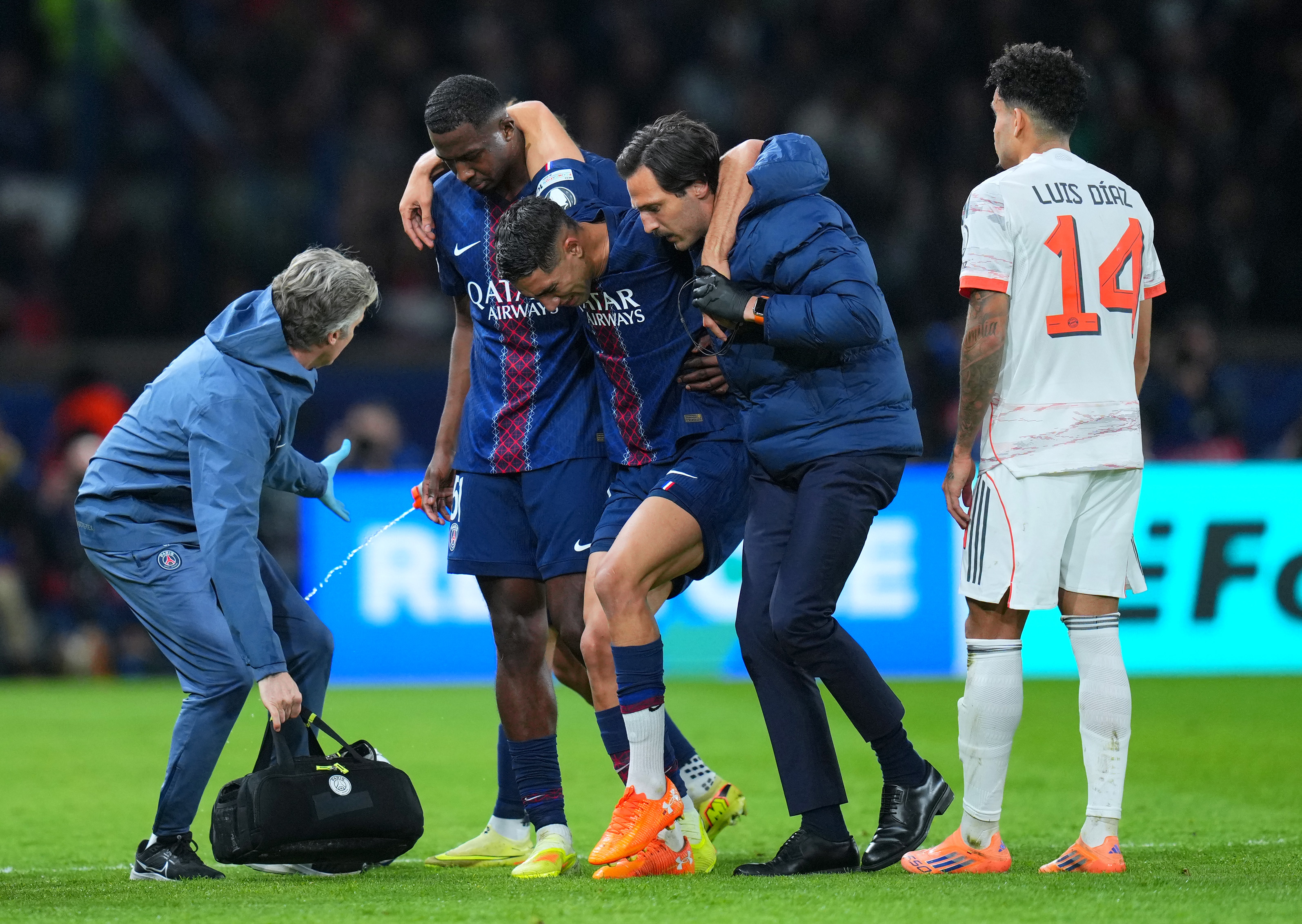 PSG’s Achraf Hakimi is helped off the pitch with an ankle injury after being fouled by Diaz, far right, just before half-time