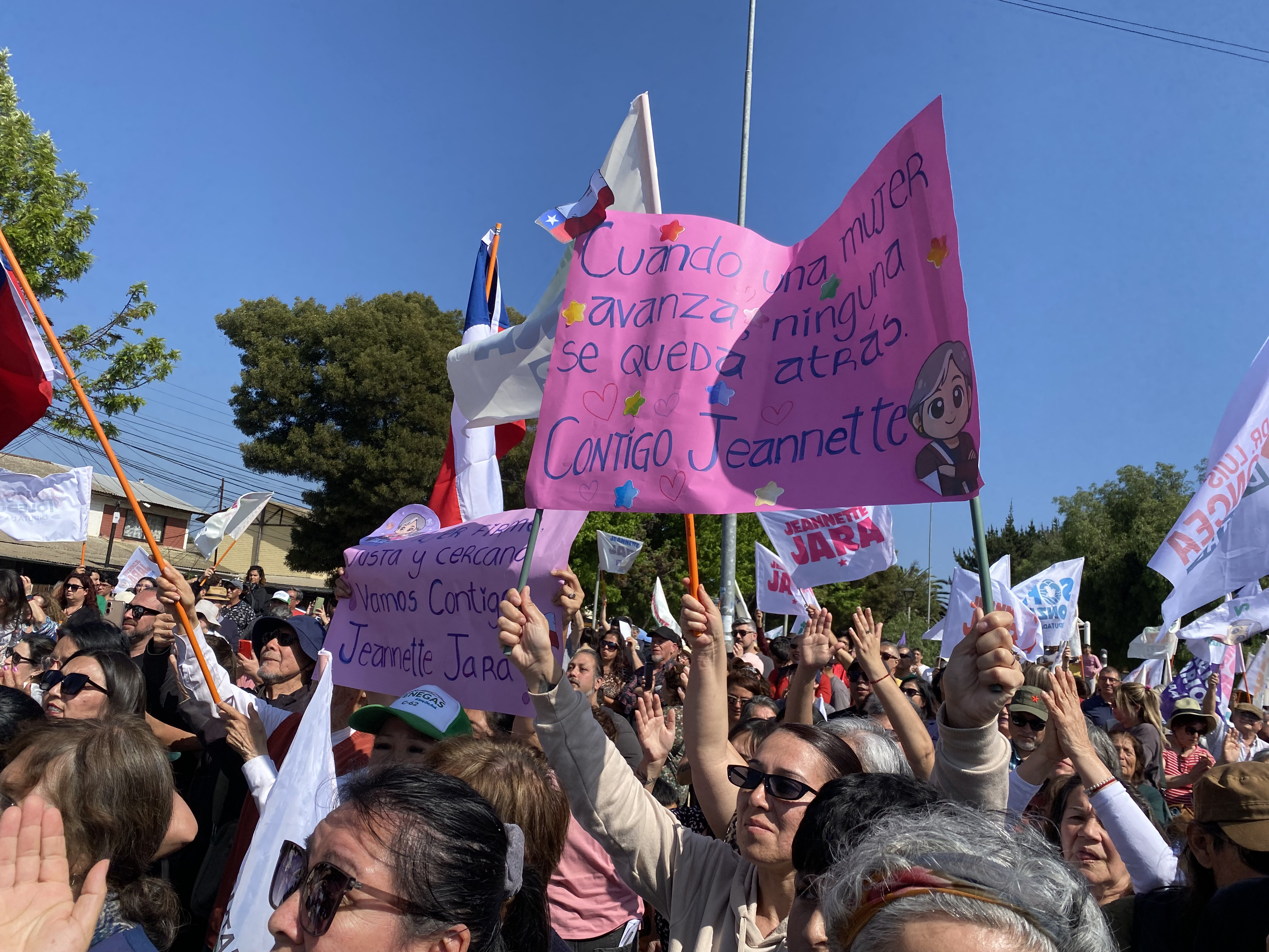 A woman holds up a sign in support of Jeannette Jara at an outdoor rally