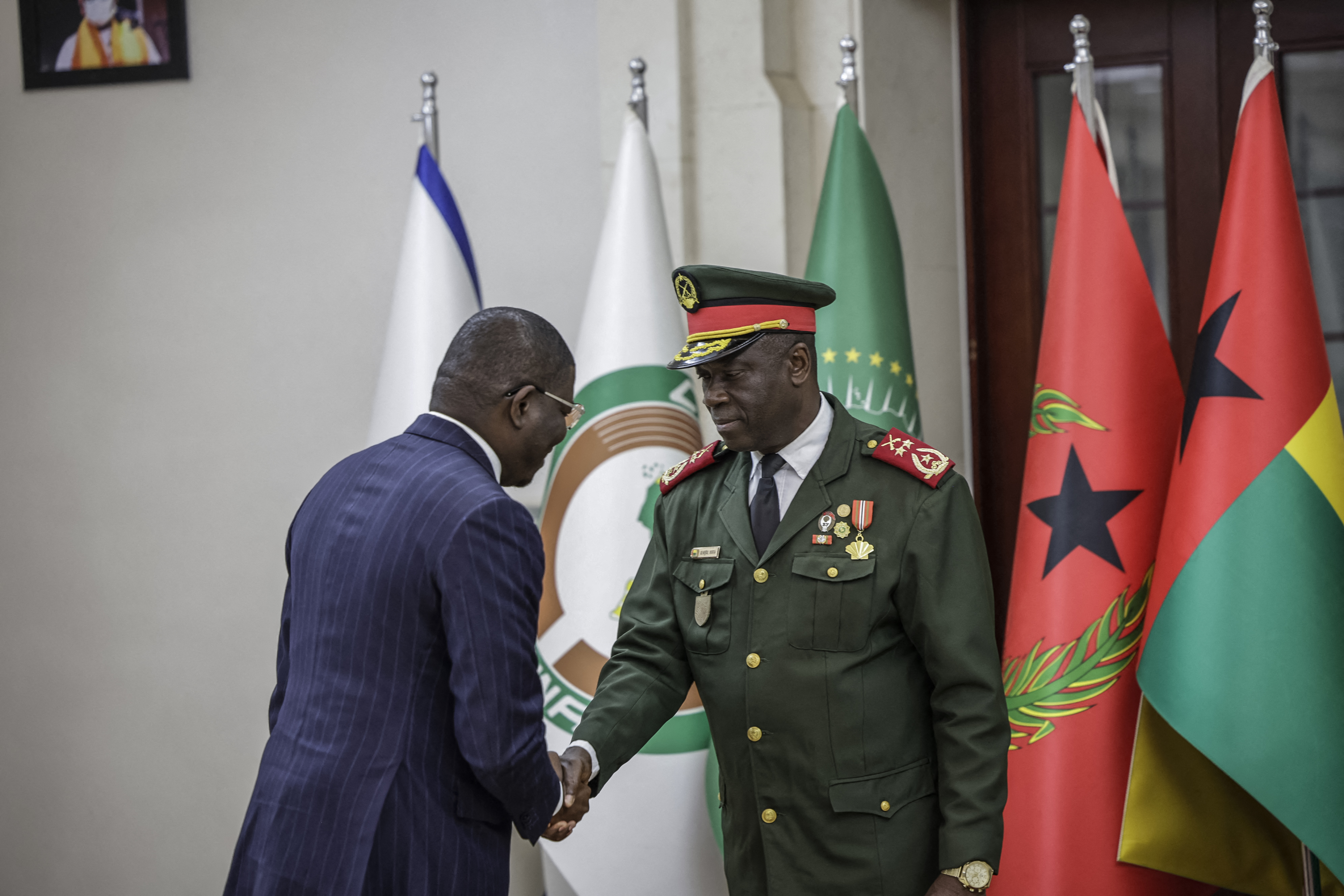Guinea Bissau newly appointed Prime Minister and Finance Minister of the transitional government Ilidio Vieira Te (L) shakes hands with transitional government President, General Horta N'Tam (R) during the swearing in ceremony at the Presidential Palace in Bissau, on November 28, 2025.