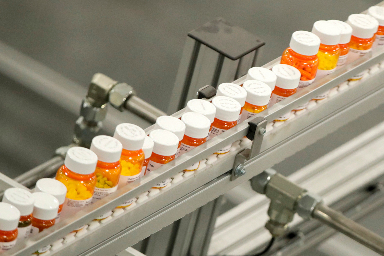 FILE - Bottles of medicine ride on a conveyor belt at a mail-in pharmacy warehouse in Florence, N.J., on July 10, 2018. (AP Photo/Julio Cortez, File)