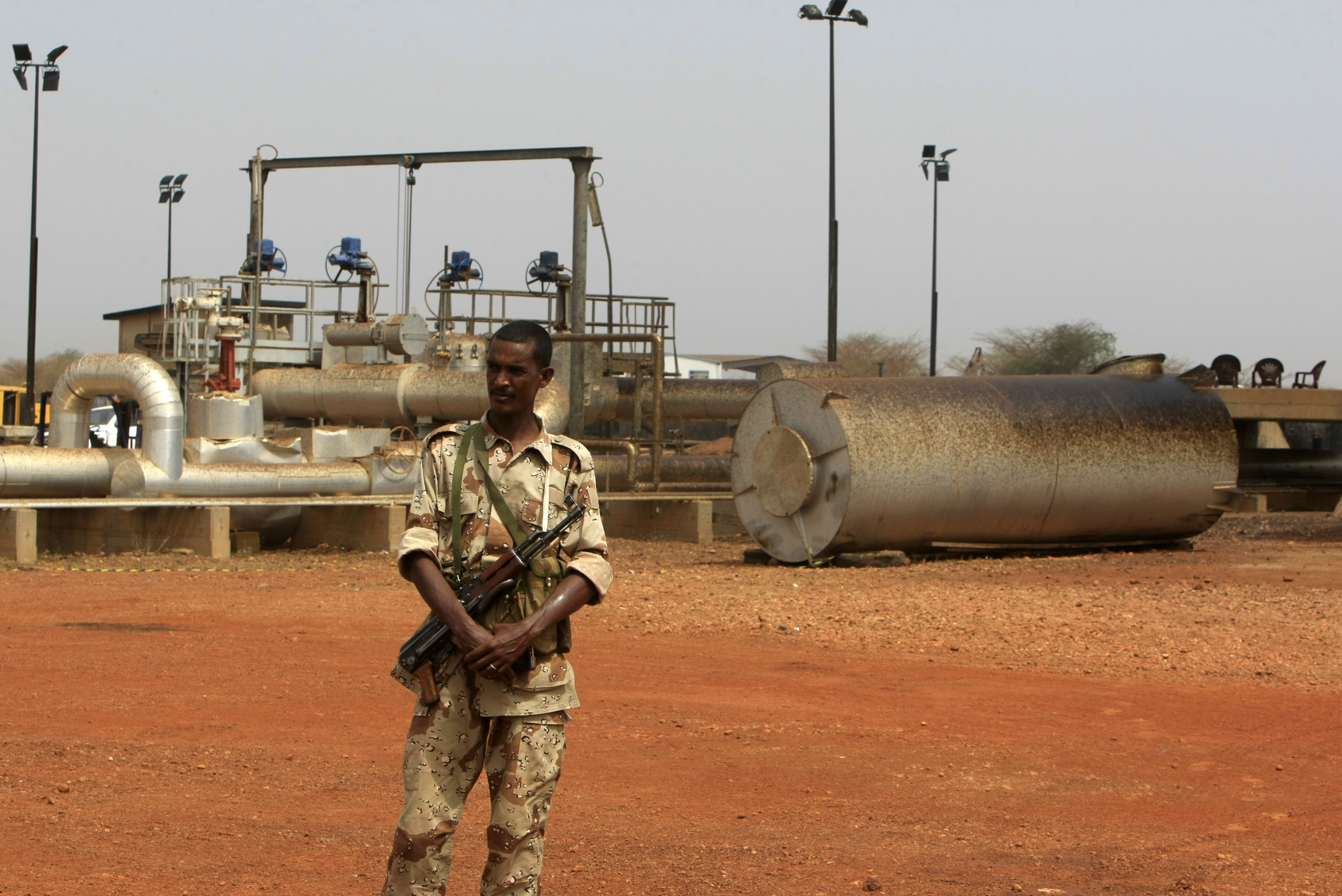 A soldier stands guard near oil pump stations.