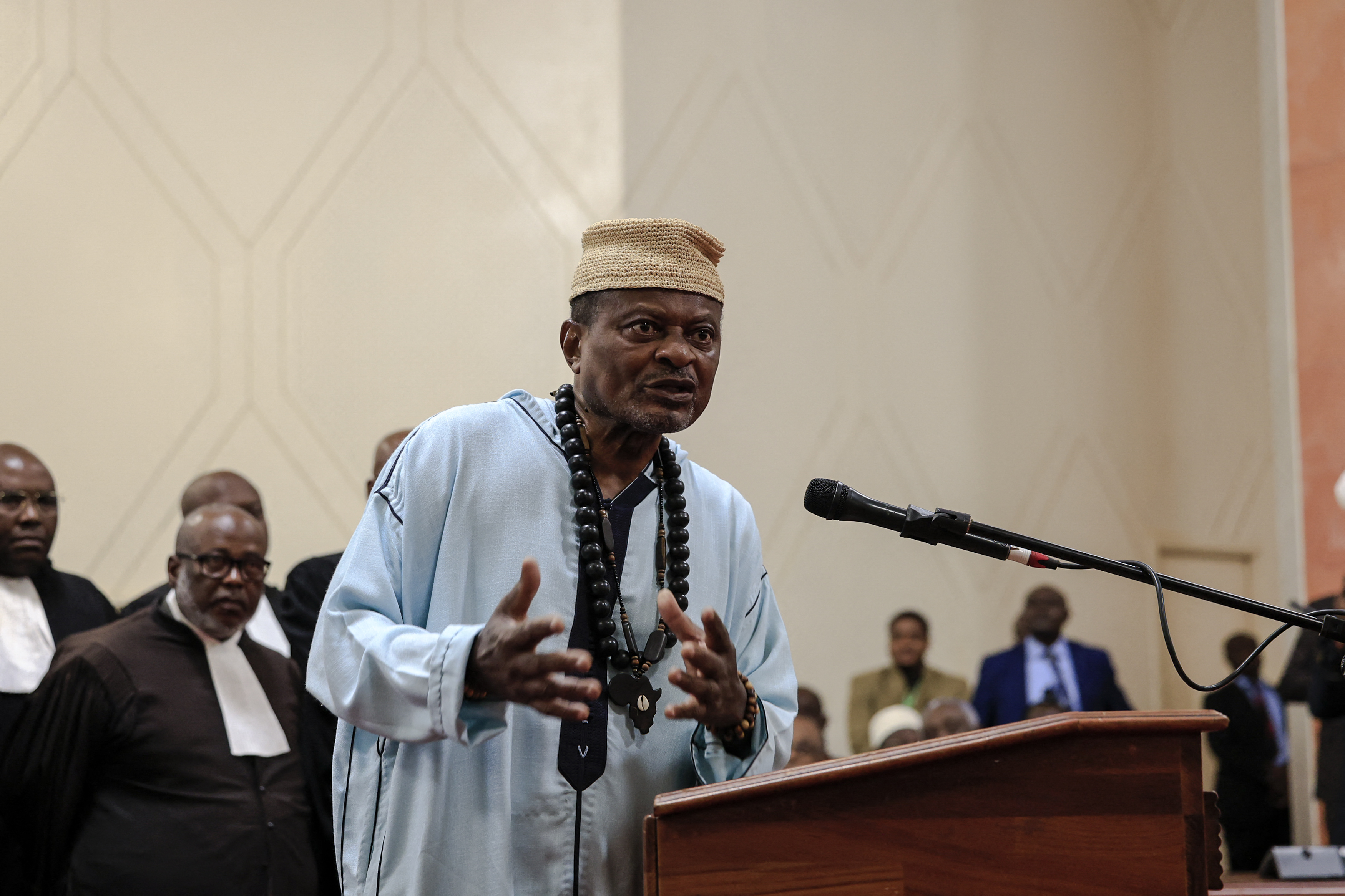 Cameroonian politician Anicet Ekane, director of the MANIDEM political party, is seen with councelors as he attends the appeals hearing at the Constitutional Council, in Yaounde on August 4, 2025. The Cameroonian opposition figure Anicet Ekane passed away Monday morning while in detention in Yaoundé, Valentin Dongmo, vice-president of the African Movement for New Independence and Democracy (Manidem), the party he led, told AFP. (Photo by AFP)