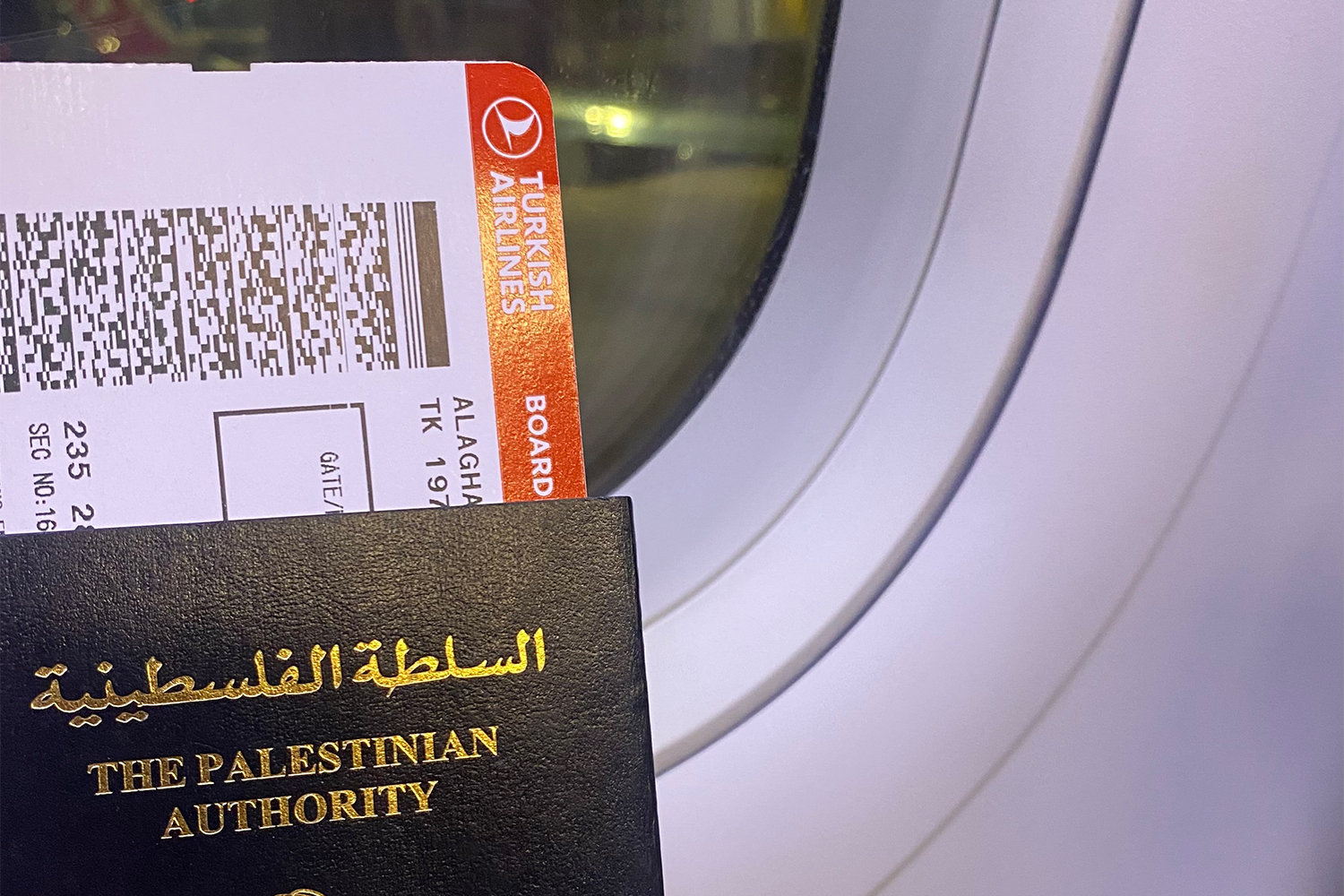 a passport held up against an aeroplane window