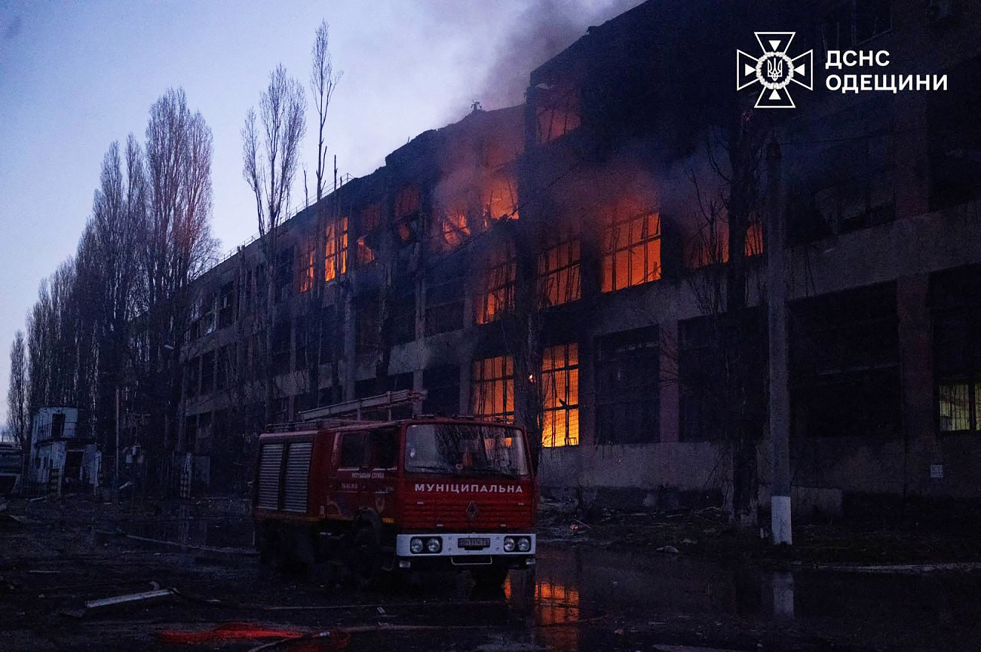 In this handout photograph taken and released by the Ukrainian Emergency Service on December 13, 2025, a fire truck is parked next to a burning building following an air attack at an undisclosed location in the Odesa region, amid the Russian invasion of Ukraine.