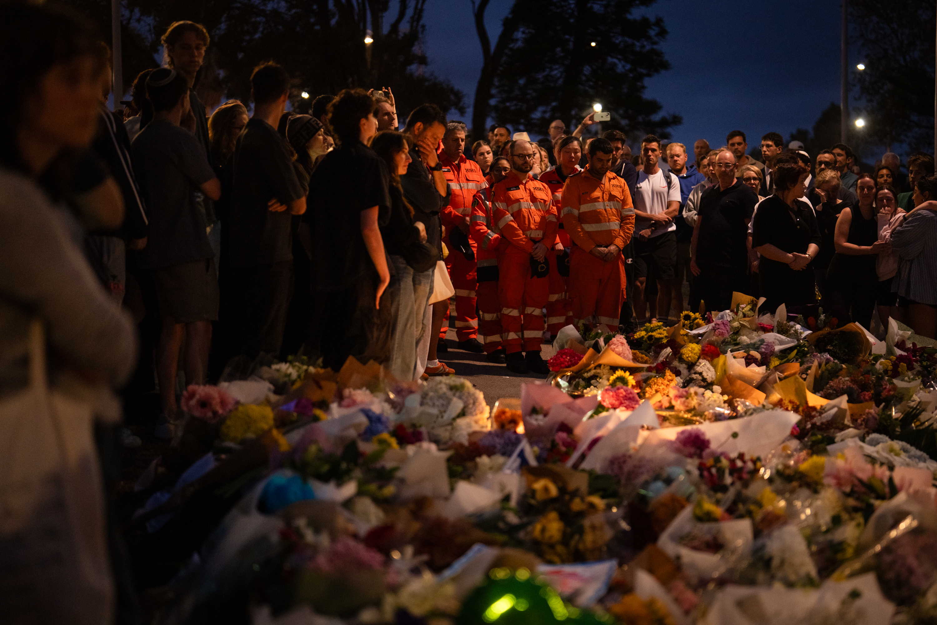 SYDNEY, AUSTRALIA - DECEMBER 16: New South Wales State Emergency Service participates in a candlelight vigil at Bondi Pavilion at Bondi Beach on December 16, 2025 in Sydney, Australia. Police say at least 16 people, including one suspected gunman, were killed and more than a dozen others injured when two attackers opened fire near a Hanukkah celebration at the world-famous Bondi Beach, in what authorities have declared a terrorist incident. The government is moving to tighten gun laws across the country. (Photo by Audrey Richardson/Getty Images)