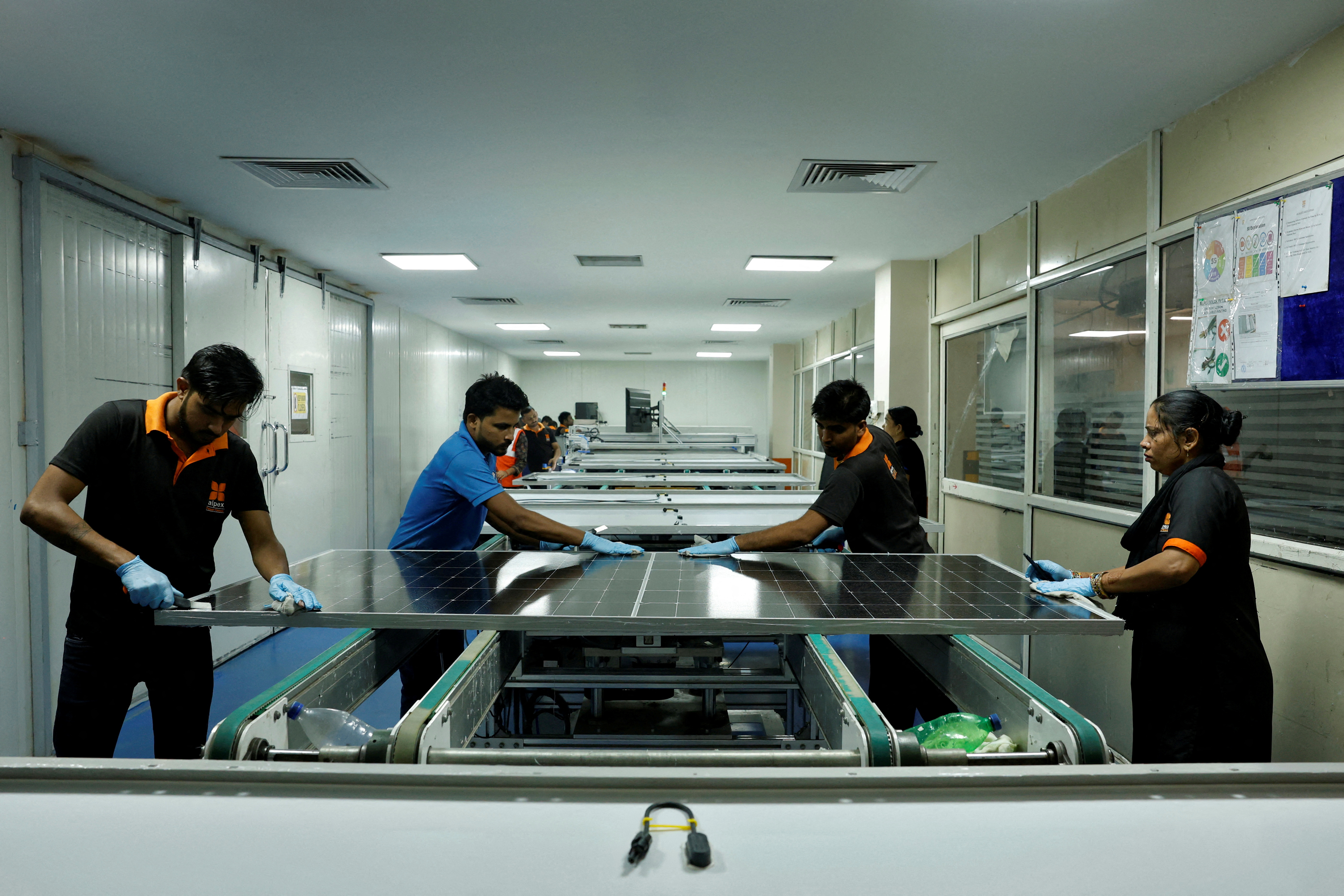 Technicians work on the assembly line in a solar manufacturing hub in Greater Noida, on the outskirts of New Delhi, India