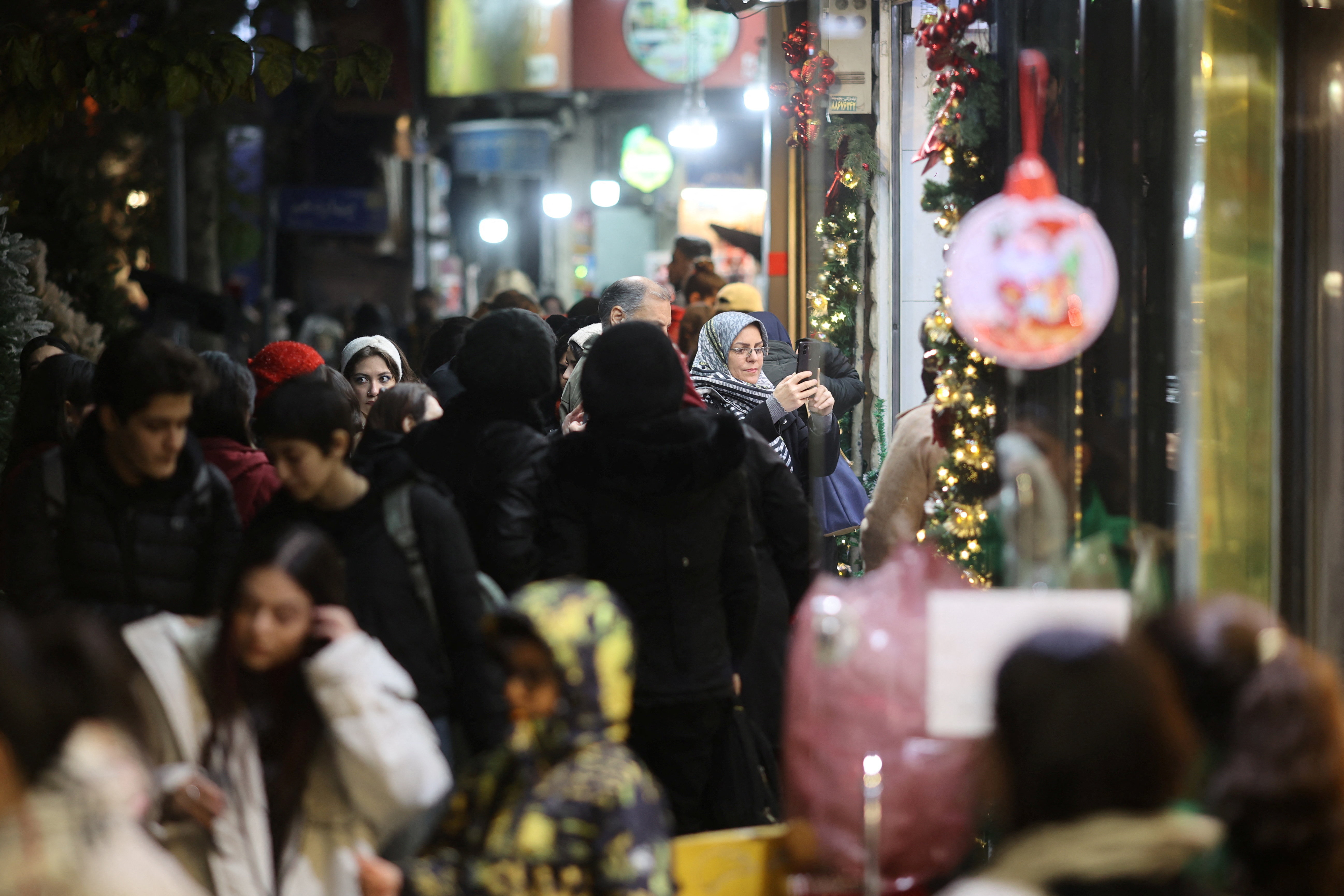 People walk past a shop selling Christmas symbols in Tehran, Iran December 24, 2025. Majid Asgaripour/WANA (West Asia News Agency) via REUTERS ATTENTION EDITORS - THIS PICTURE WAS PROVIDED BY A THIRD PARTY