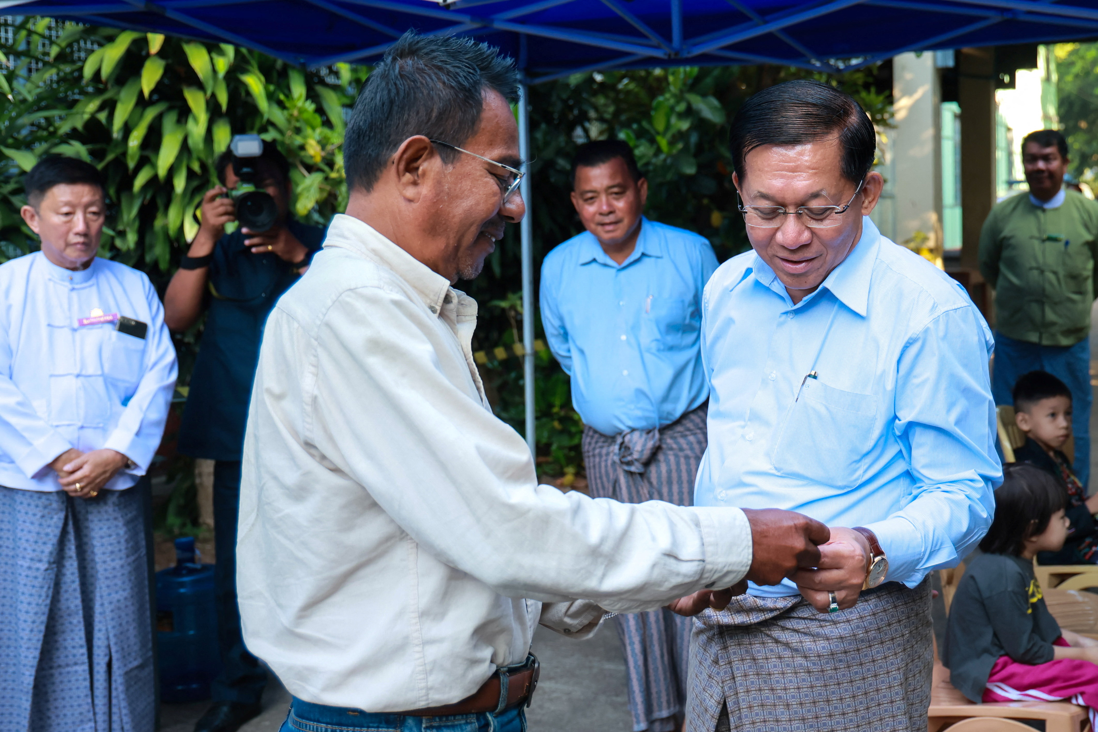 Myanmar military chief Min Aung Hlaing speaks to a man outside a polling station during the second phase of the general elections in Yangon