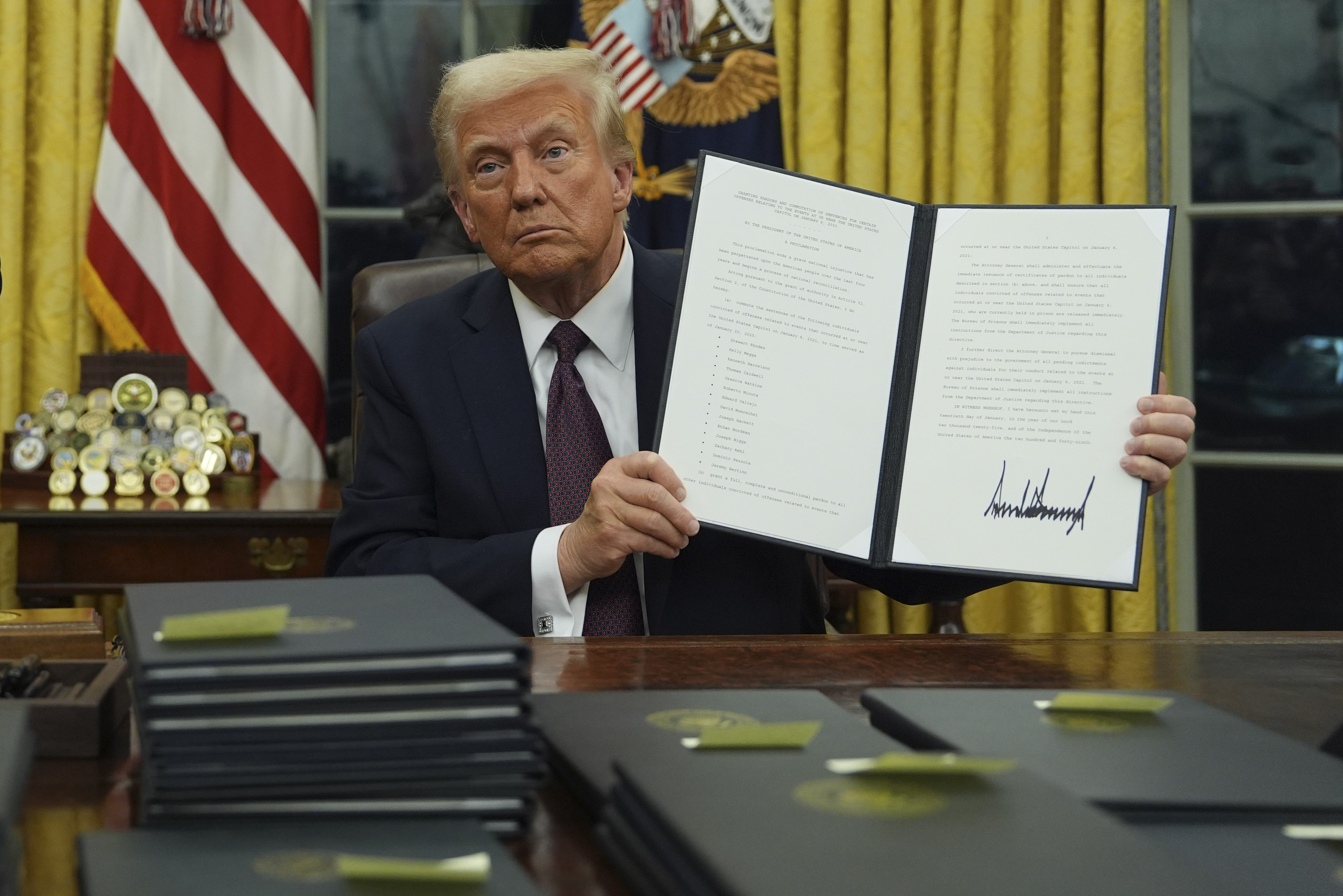 President Donald Trump holds up an executive order