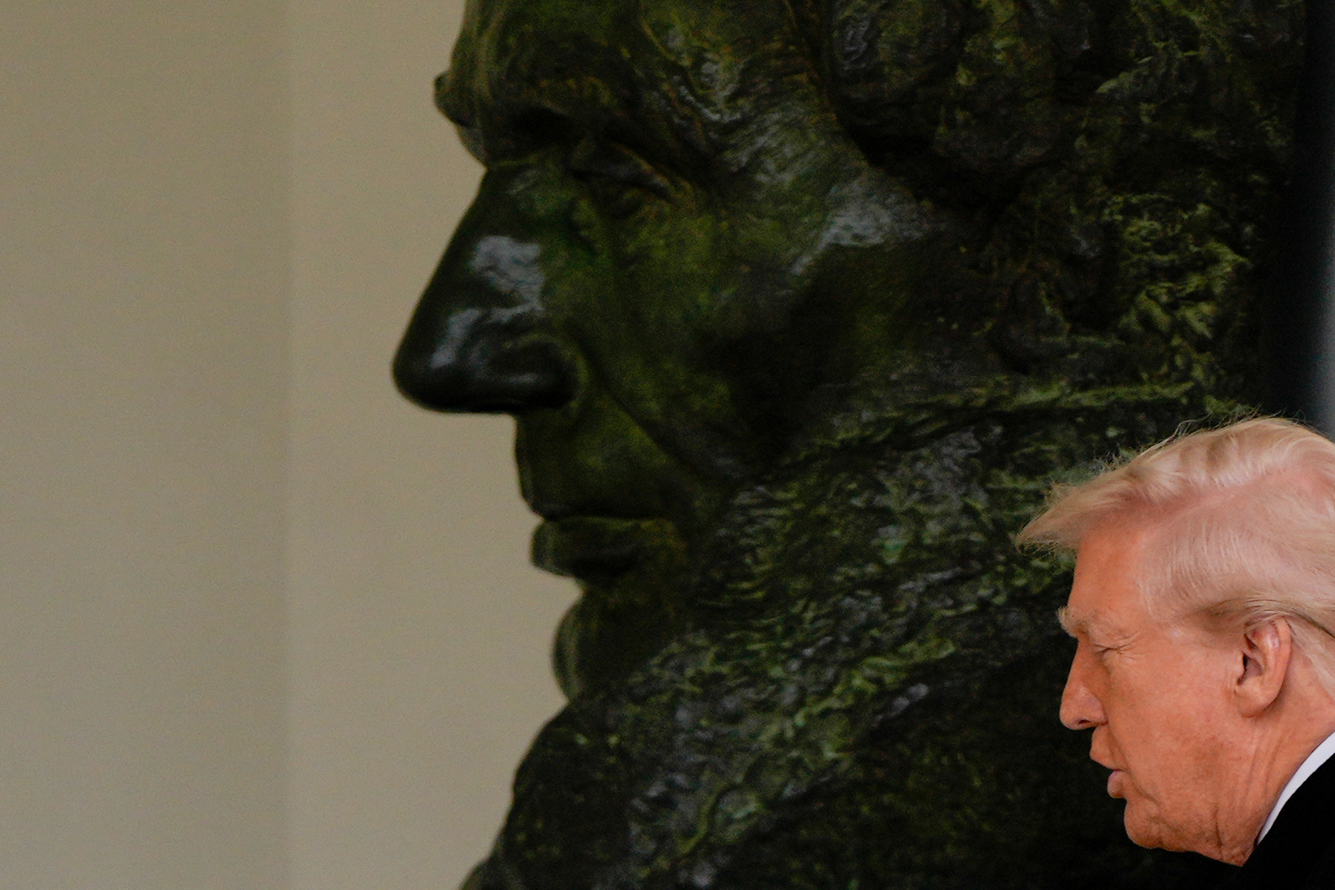 Donald Trump passes a large bust of Abraham Lincoln