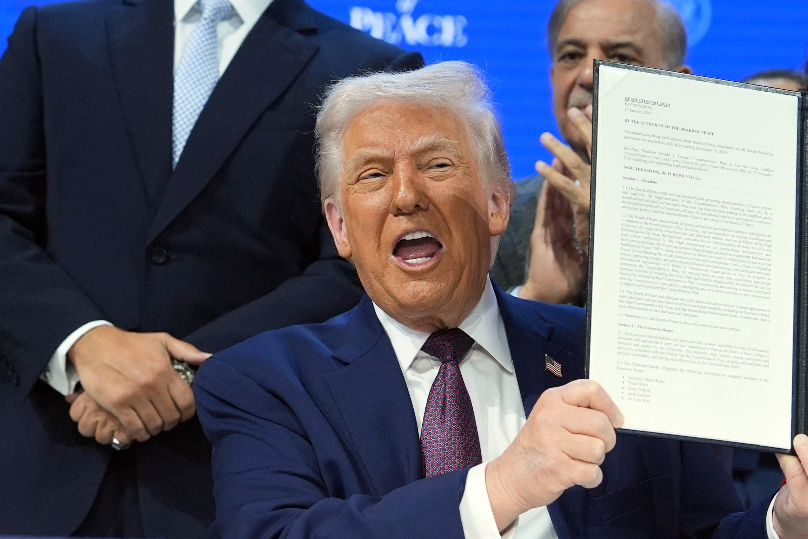 President Donald Trump, center, holds up a signed Board of Peace charter during the Annual Meeting of the World Economic Forum in Davos, Switzerland, Thursday, Jan. 22, 2026. [Evan Vucci/AP Photo]