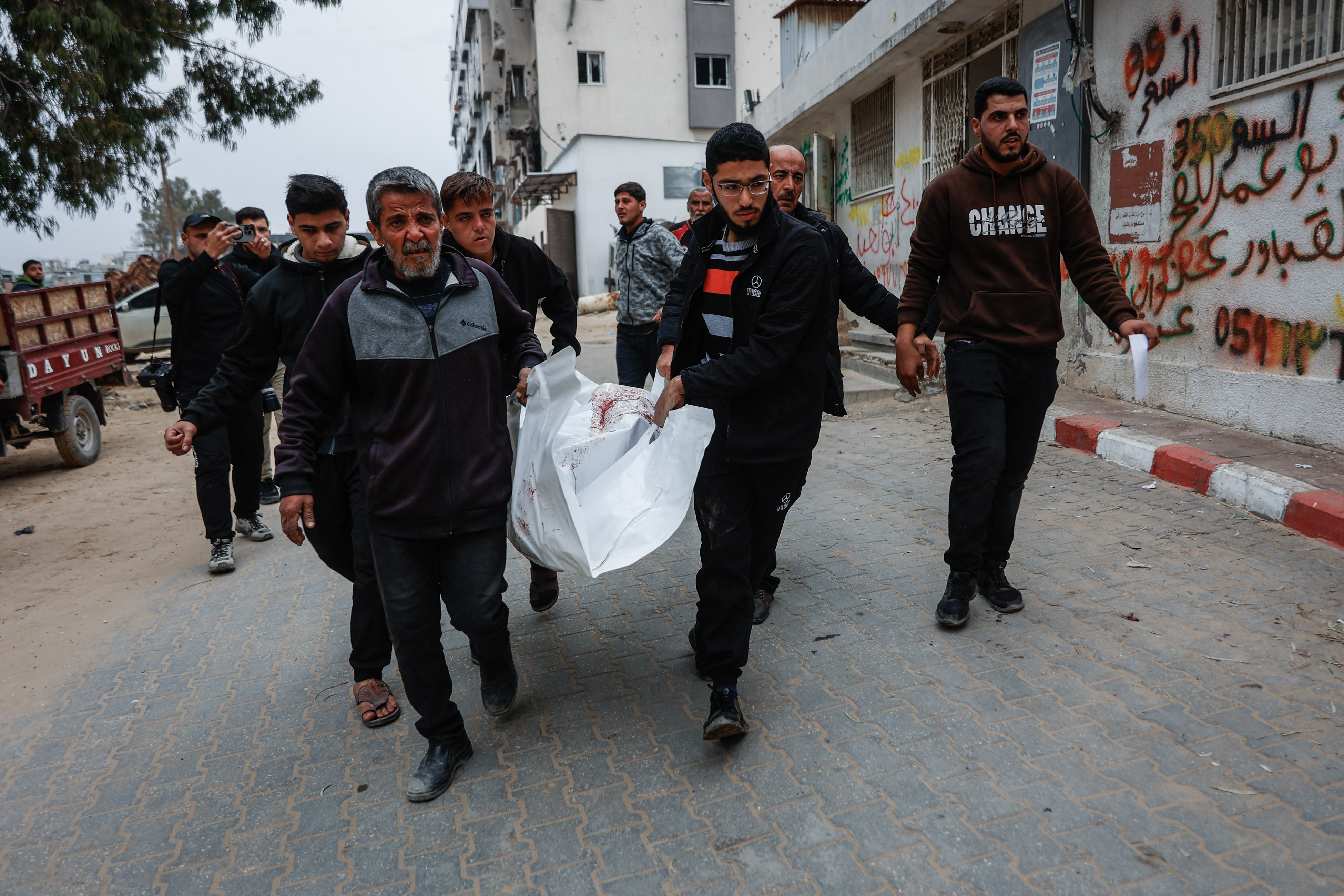 Men carry a body bag at Al-Shifa hospital after four Palestinians were killed whilst collecting firewood east of the Zeitoun neighborhood, Gaza City on January 22, 2026.