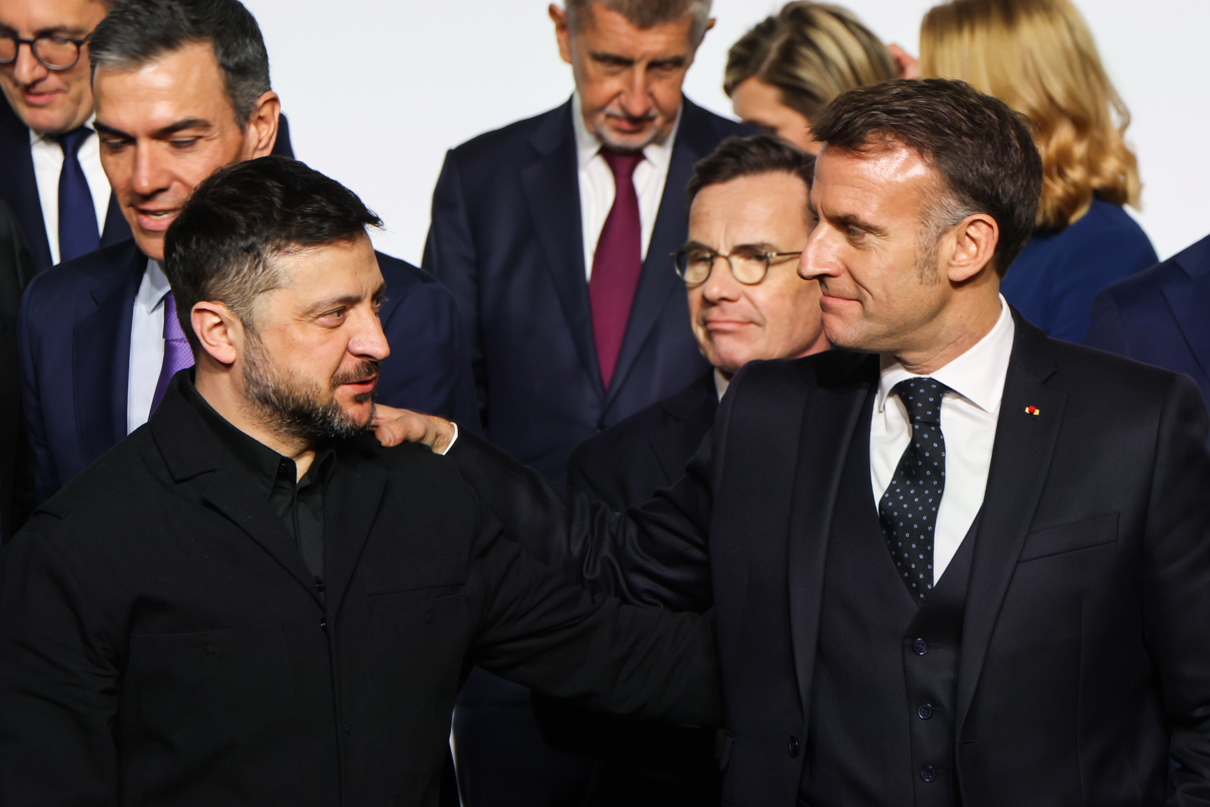 Ukraine's President Volodymyr Zelenskyy, left, and France's President Emmanuel Macron react during a family photo at the Elysee Palace in Paris, Tuesday Jan. 6, 2026, on the sideline of the Coalition of the Willing summit for Ukraine. (Ludovic Marin, Pool photo via AP)