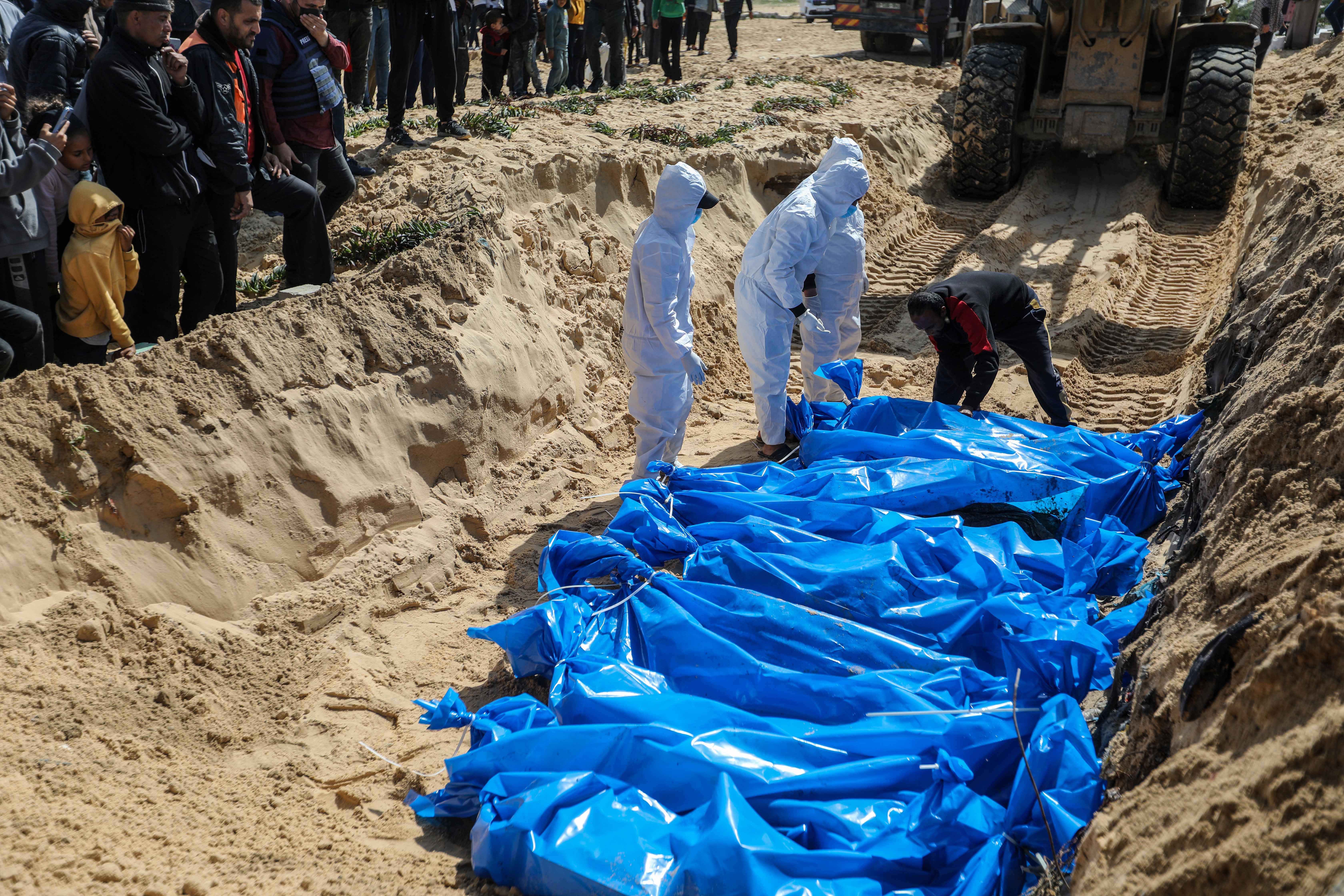 RAFAH, GAZA - MARCH 7: (Editor's Note: Image depicts death) The bodies of Palestinians killed during the war were buried in a mass grave and the Gaza Ministry of Health said 47 bodies were confiscated by Israeli forces and delivered through the Israeli-controlled Kerem Shalom crossing on March 7, 2024 in Rafah, Gaza. Negotiations being held in Cairo over a potential ceasefire deal appear to have stalled, as the current war between Israel and Hamas reaches the five-month mark. More than 30,000 people have died in Gaza as a result of the war, according to the Hamas-run health ministry. The Israeli government says that between 100 and 130 hostages remain captive in Gaza, after being kidnapped by Hamas militants in a surprise Oct. 7 attack that left around 1,200 dead in Israel. (Photo by Ahmad Hasaballah/Getty Images)