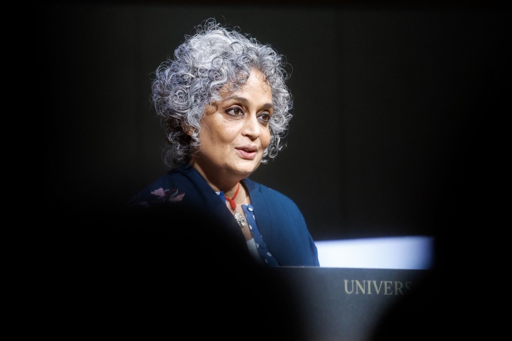 a woman with grey curly hair against a dark background
