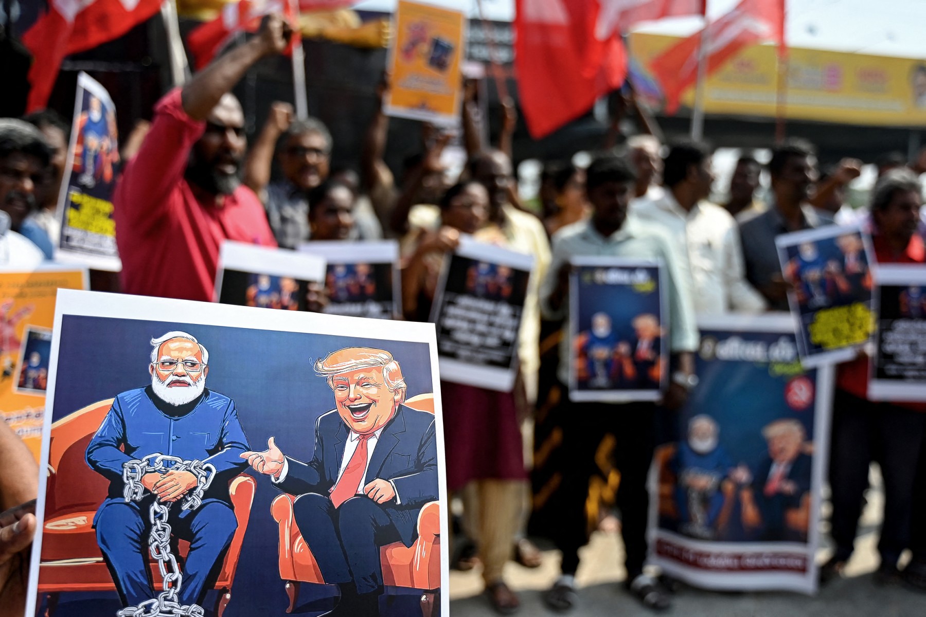 Members of the Communist Party of India (Marxist), holding placards with caricatures of India’s Prime Minister Narendra Modi (L) and United States President Donald Trump, shout slogans in Chennai on February 17, 2025, during a protest to condemn the treatment of unregistered migrants deported from the US to India