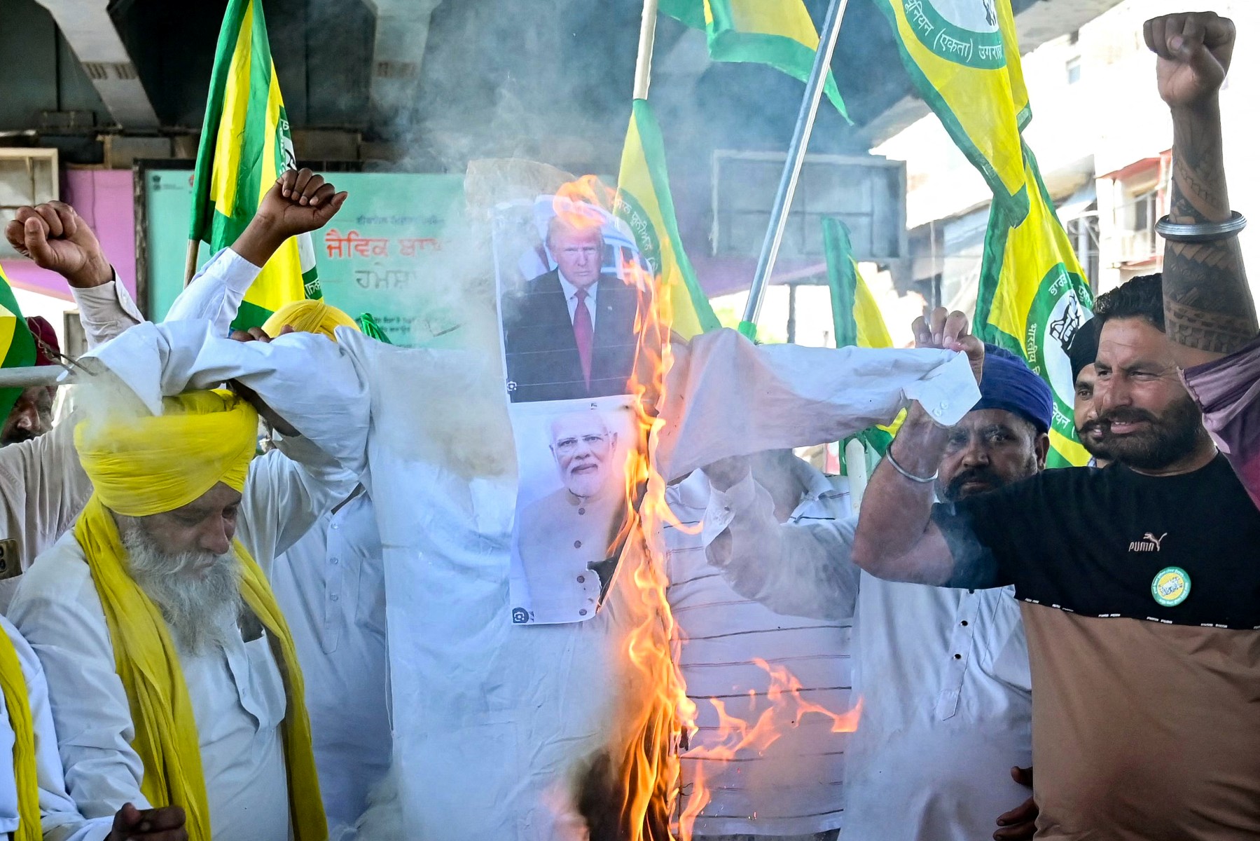 Farmers burn an effigy of US President Donald Trump (C, top) and India’s Prime Minister Narendra Modi during a protest in Amritsar on April 4, 2025, following Trump’s sweeping new tariffs on imports to the US from countries across the globe