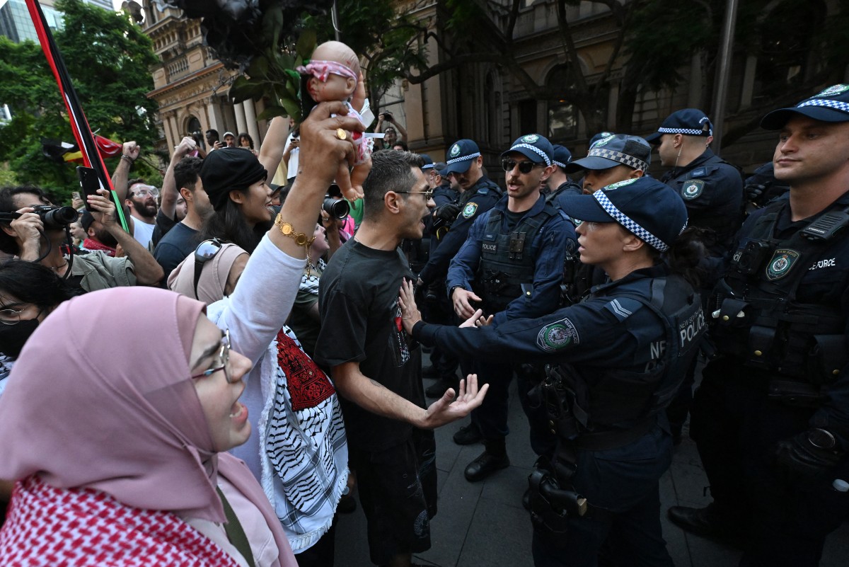 Police stand in front of Pro-Palestinian protesters during a demonstration against Israeli President Isaac Herzog's visit to Australia in Sydney on February 9, 2026.Police in the Australian city of Sydney deployed pepper spray and scuffled with protesters on February 9 as a march against a visit by Israeli President Isaac Herzog turned violent, an AFP journalist said.