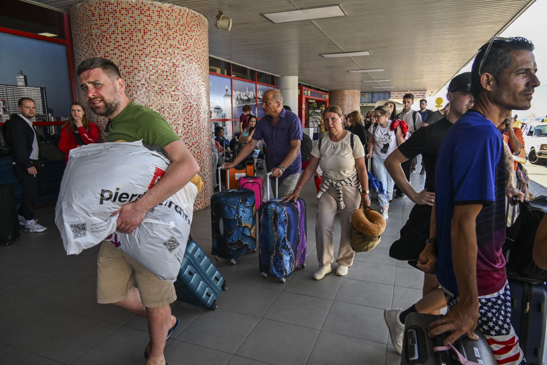 Russian tourists prepare to board a return flight at Jose Marti International Airport in Havana on February 16, 2026. In early February 2026, Havana announced it was suspending jet fuel supplies over the energy crisis, prompting Canadian and Russian airlines and Latin American carrier LATAM to repatriate stranded passengers before suspending flights.