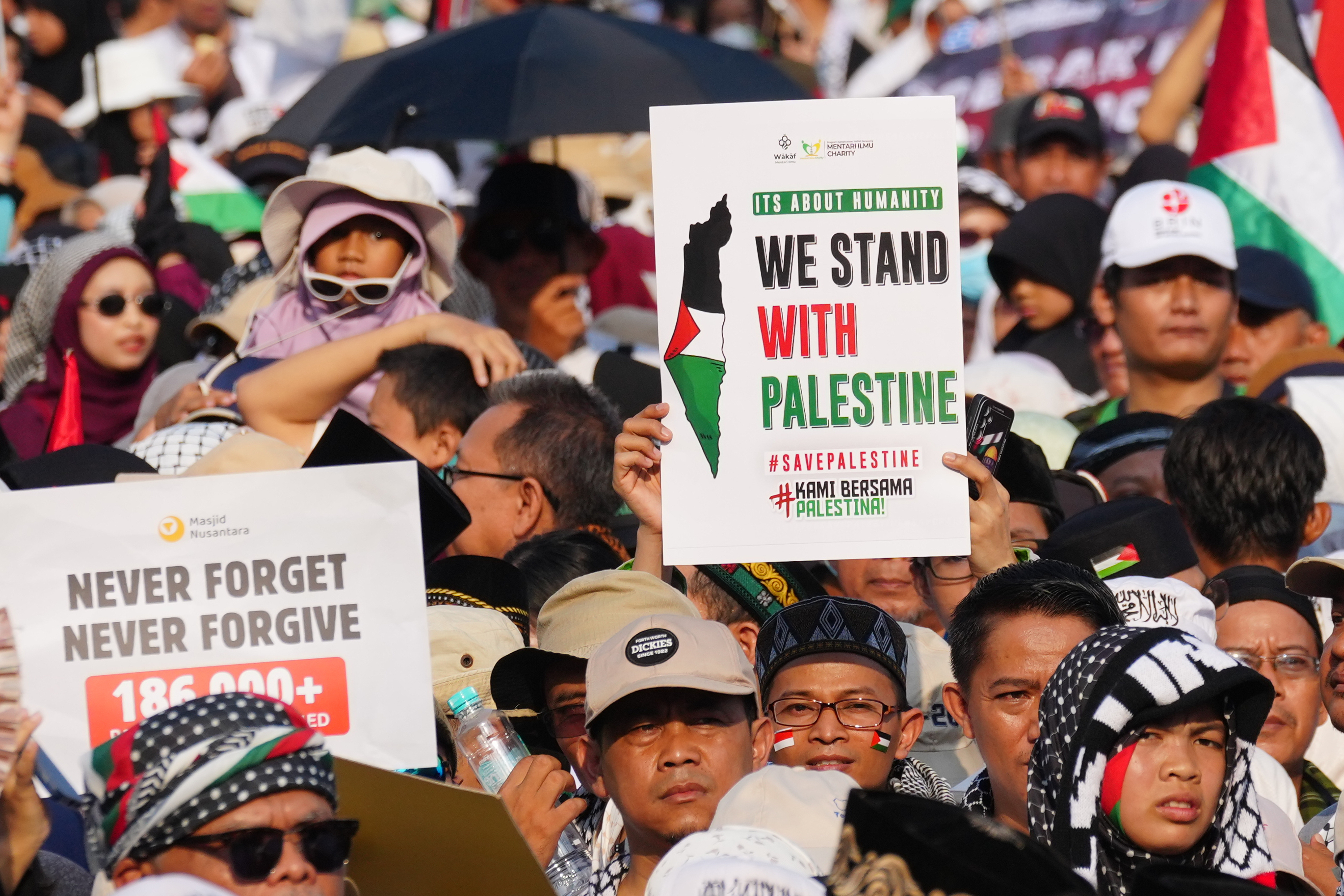 Protesters hold up posters during a rally in solidarity of the Palestinians in Gaza, in Jakarta, Indonesia, Sunday, Oct. 12, 2025. (AP Photo/Tatan Syuflana)