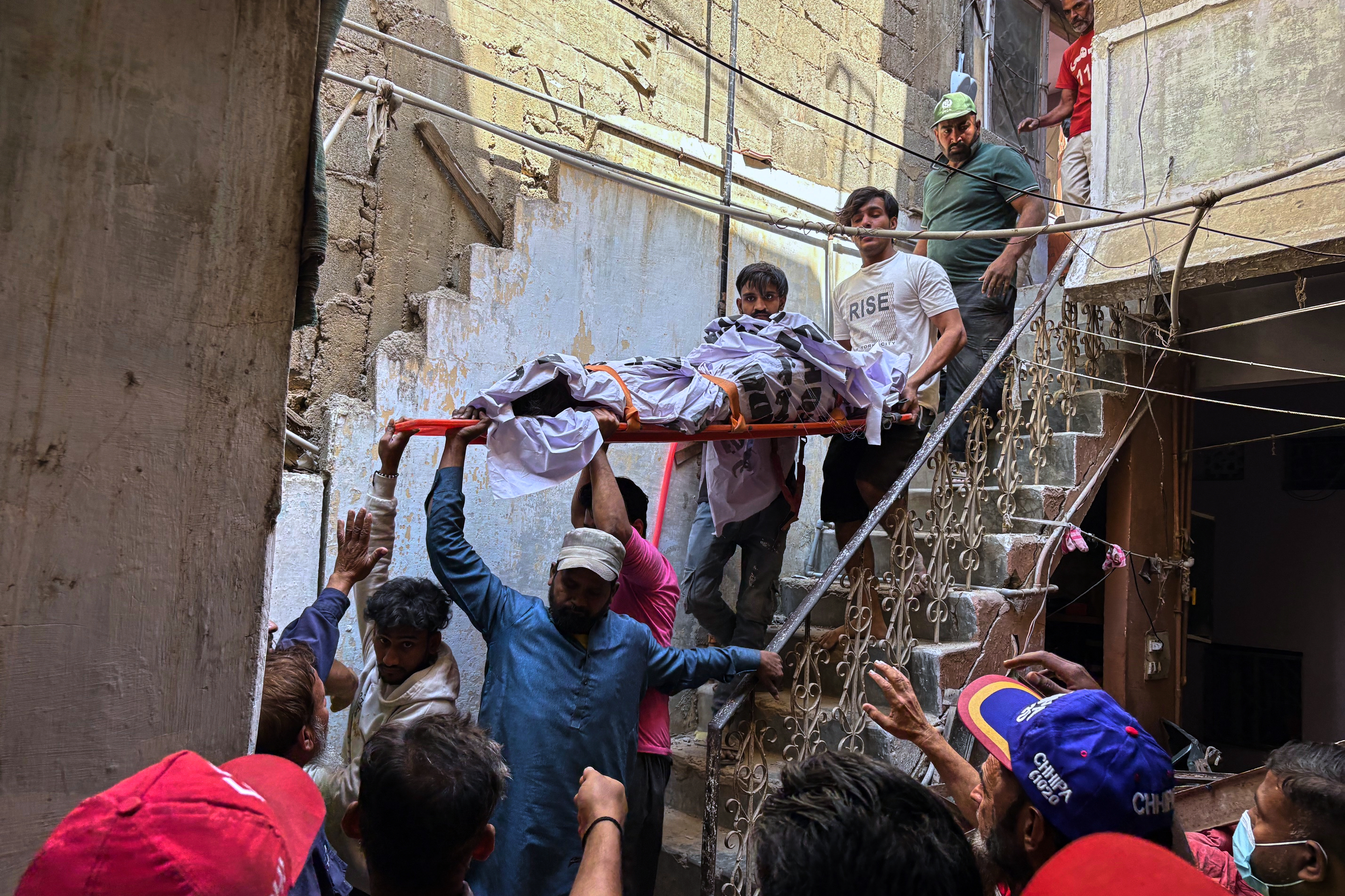 Rescue workers carry a body out of a building.