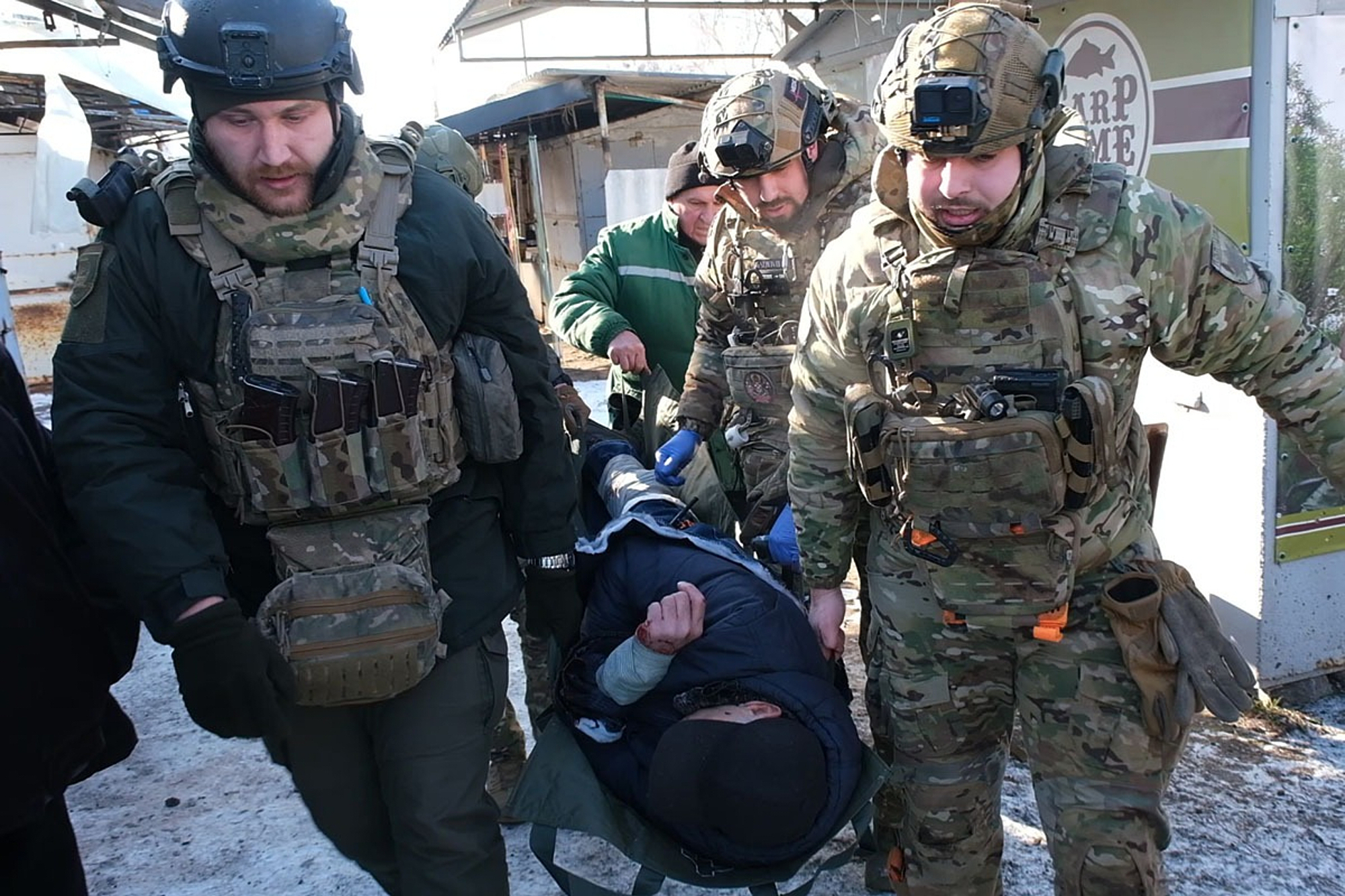 This photo provided by the Ukrainian Police Press Service, military paramedics carry a wounded civilian after a Russian shelling of the local market in the town of Druzhkivka, Donetsk region, eastern Ukraine, Wednesday, Feb. 4, 2026. (Ukrainian Police Press Service via AP)