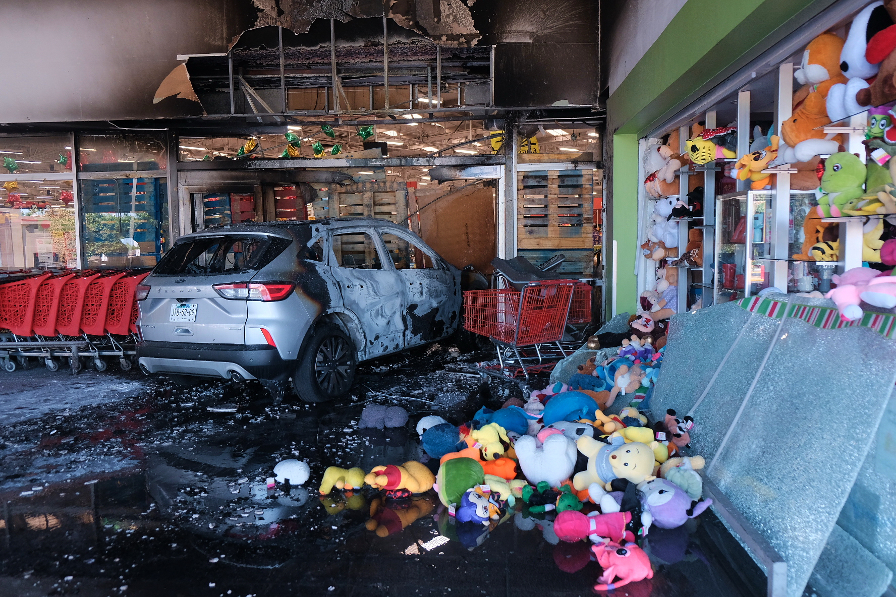 A charred vehicle sits at a damaged supermarket in Guadalajara, Jalisco state, Mexico