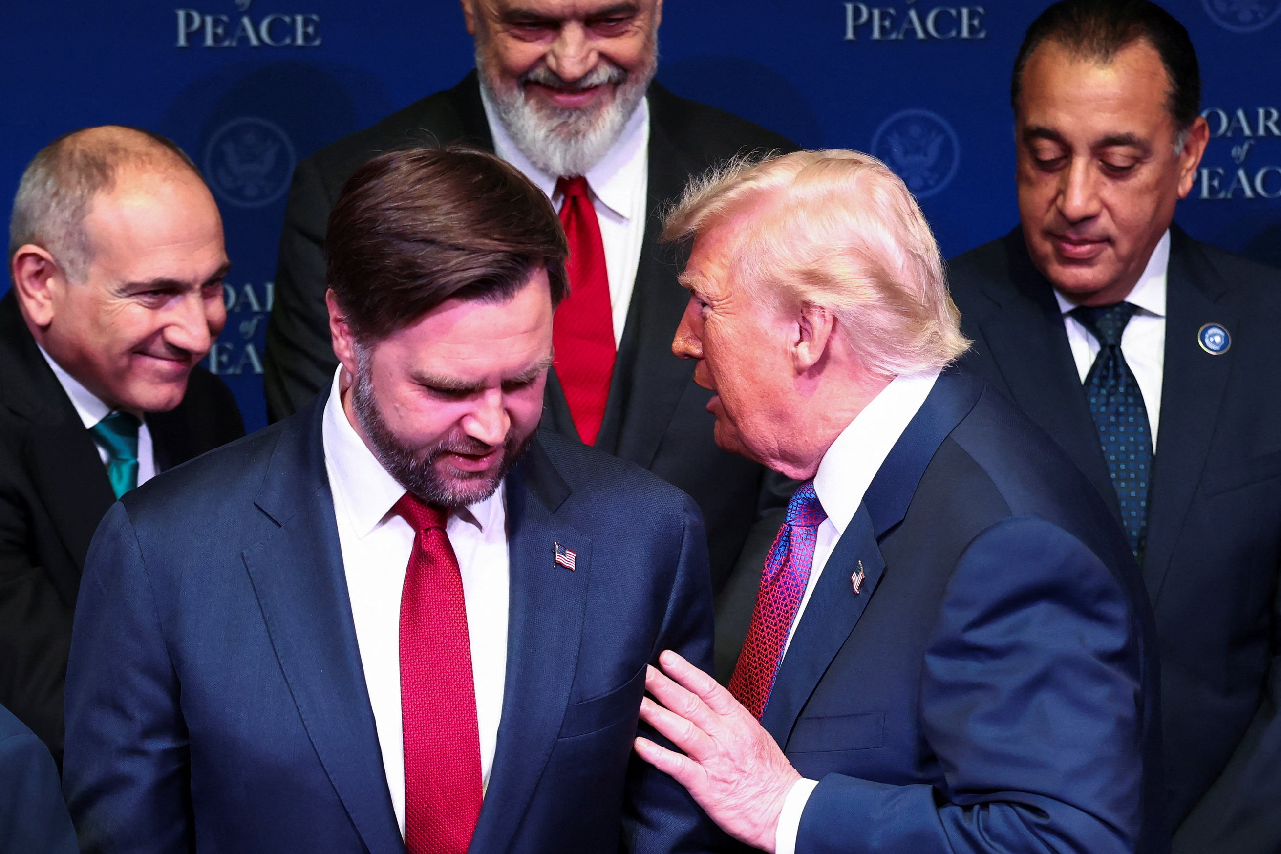 U.S President Donald Trump talks to U.S. Vice President JD Vance as they stand with world leaders participating in the inaugural Board of Peace meeting at the U.S. Institute of Peace in Washington, D.C., U.S., February 19, 2026. REUTERS/Kevin Lamarque