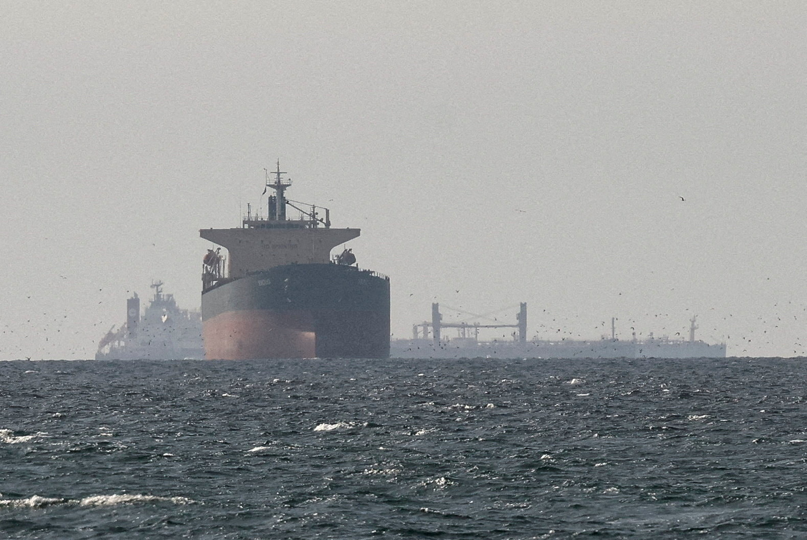 Cargo ships in the Gulf, near the Strait of Hormuz, as seen from northern Ras al-Khaimah, near the border with Oman’s Musandam governance, amid the U.S.-Israeli conflict with Iran, in United Arab Emirates, March 11, 2026. [Stringer/Reuters]