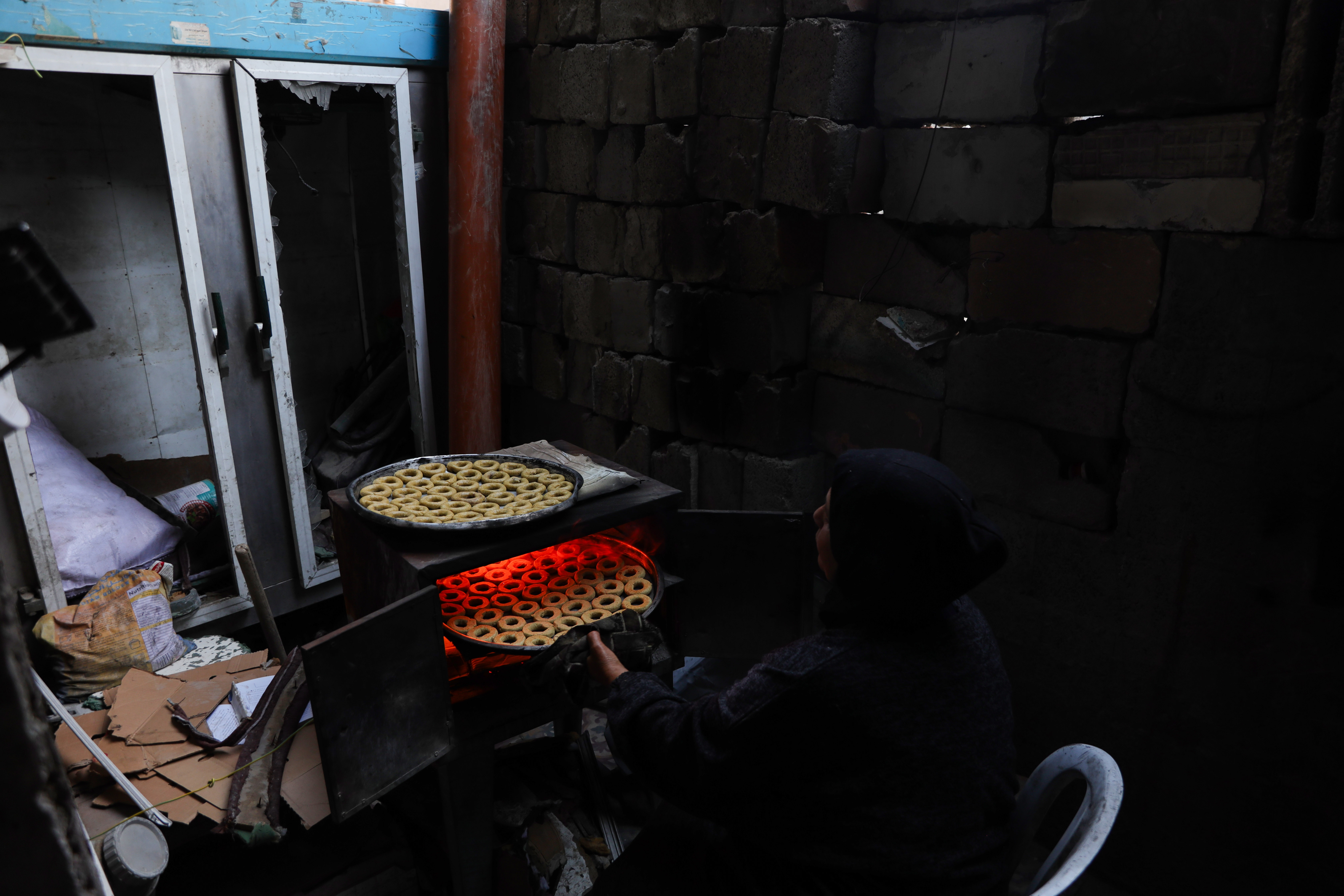 woman putting tray of cookies into an oven
