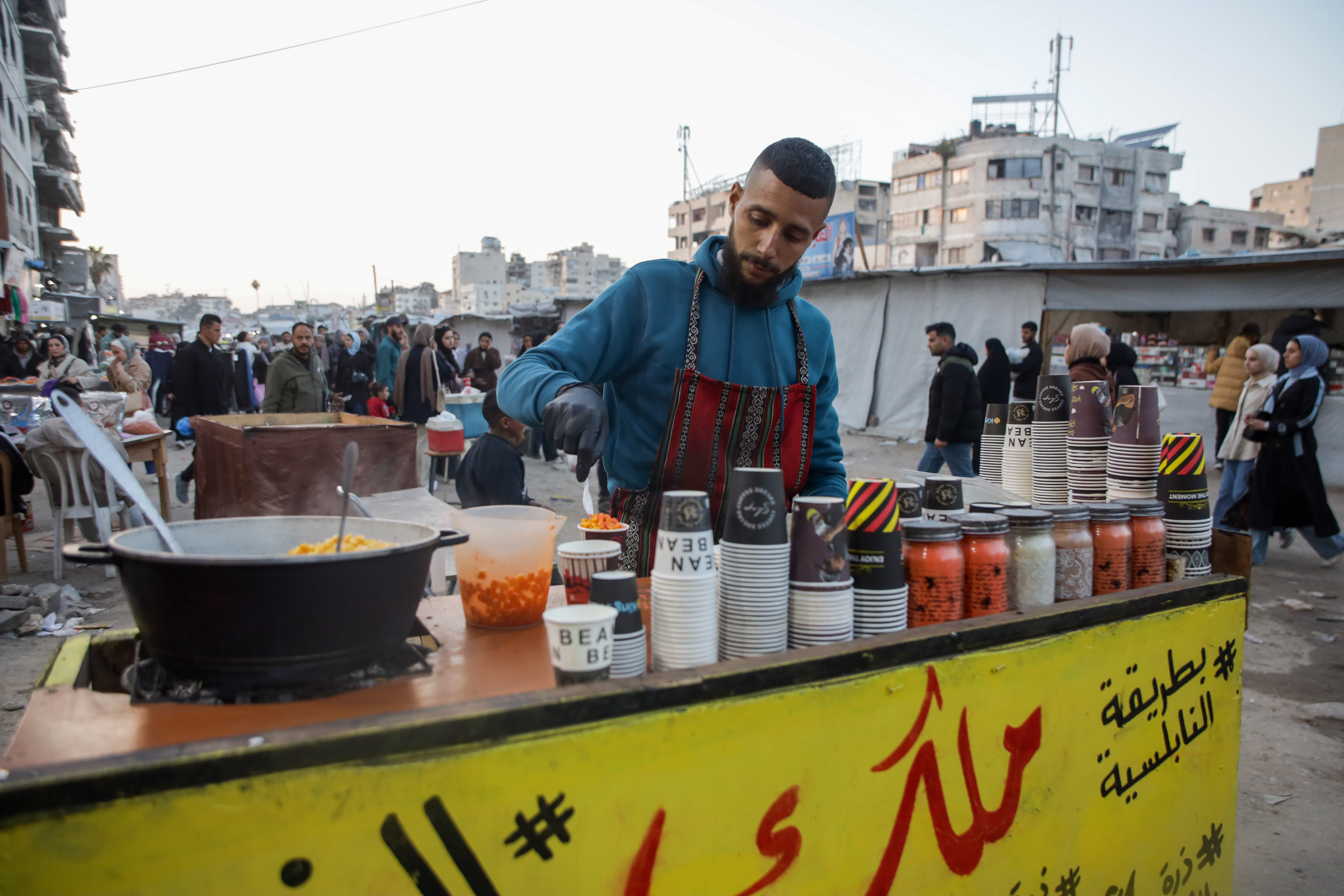 Mustafa Bulbul, who holds a degree in business administration, currently runs a small stall selling boiled corn in Al-Rimal market in Gaza [Abdelhakim Abu Riash/ Al Jazeera]