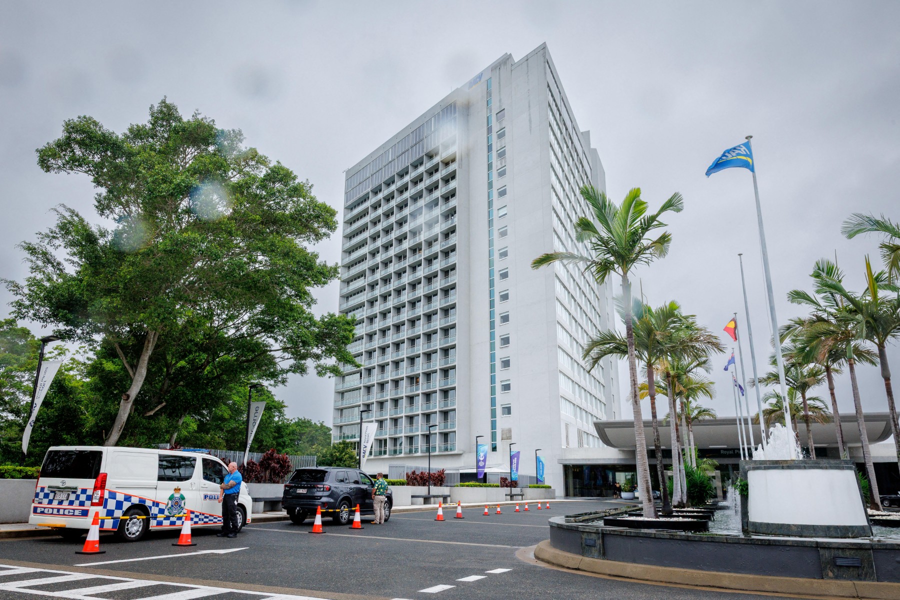 A hotel security member stands beside a police van (L) at the entrance to the Royal Pines Resort, where members of the Iranian womens football team are staying, on the Gold Coast on March 9, 2026. Australia must protect the visiting Iranian women's football team, the son of the nation's late shah urged March 9, warning their refusal to sing the national anthem before a match could have "dire consequences". (Photo by Patrick HAMILTON / AFP)