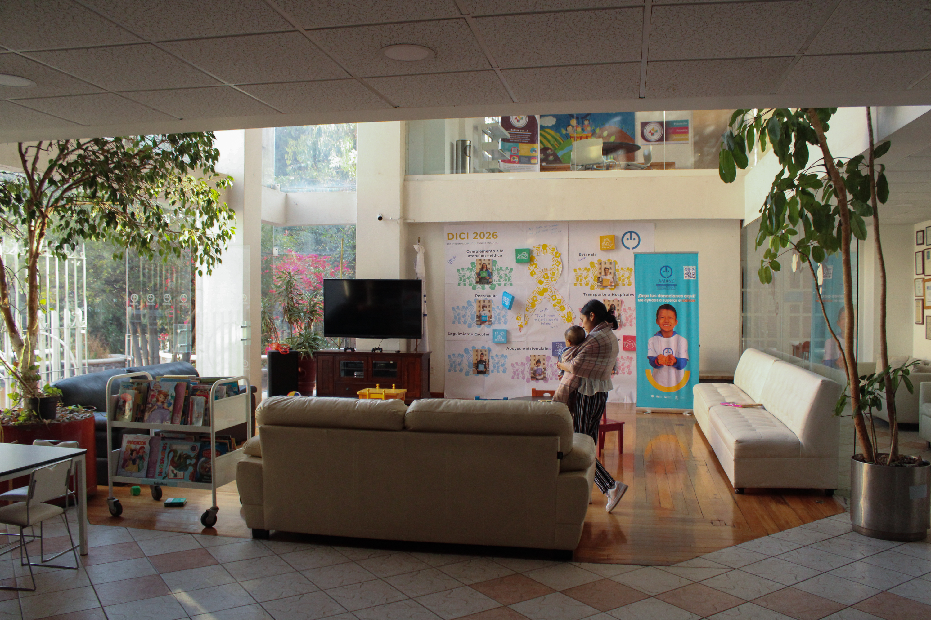 Luisa walks through the centre carrying Juan de Jesús, navigating long days of caregiving far from her home community_-1773831292