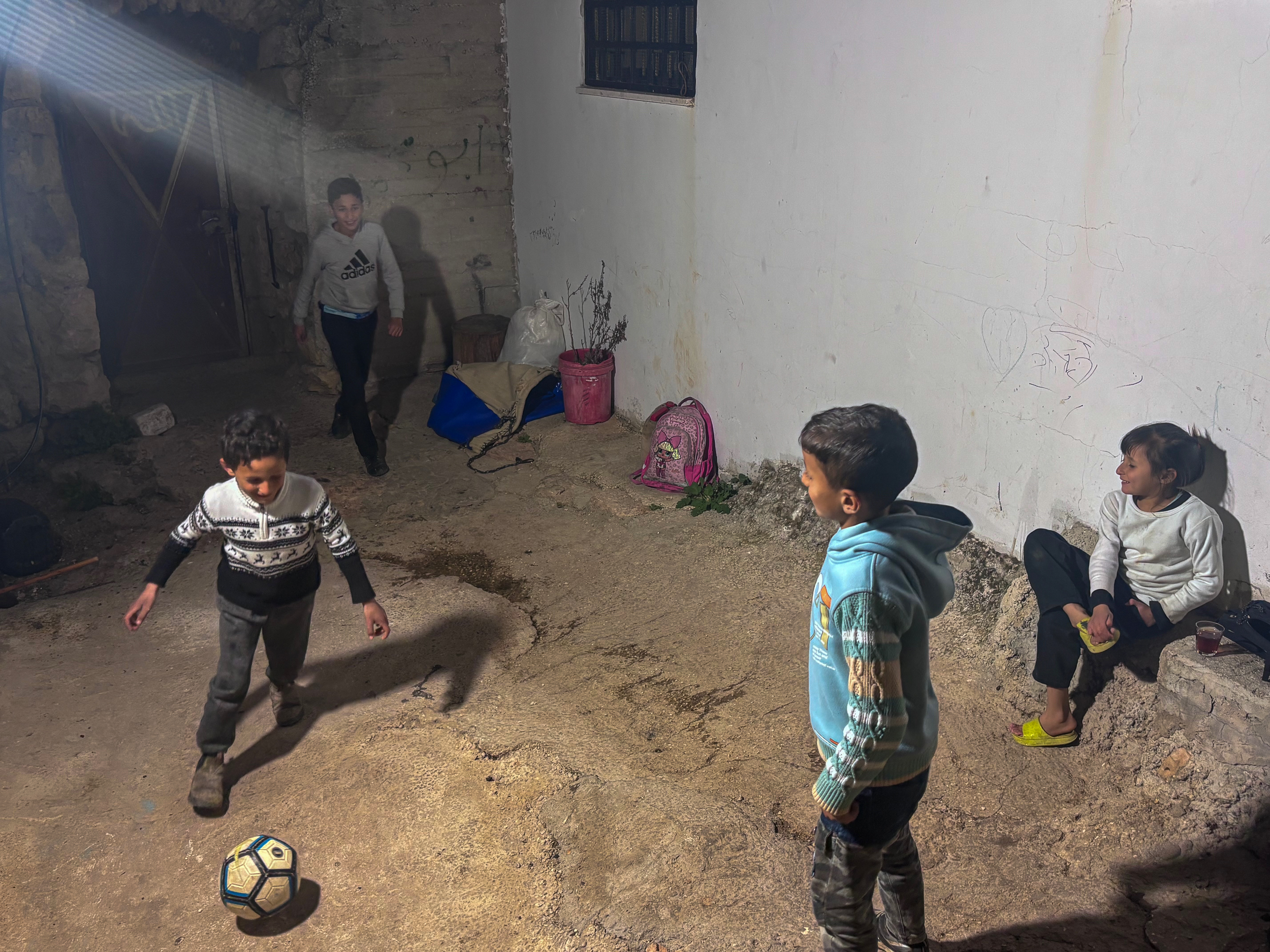 Musa Masallam playing football with his cousins in the family home