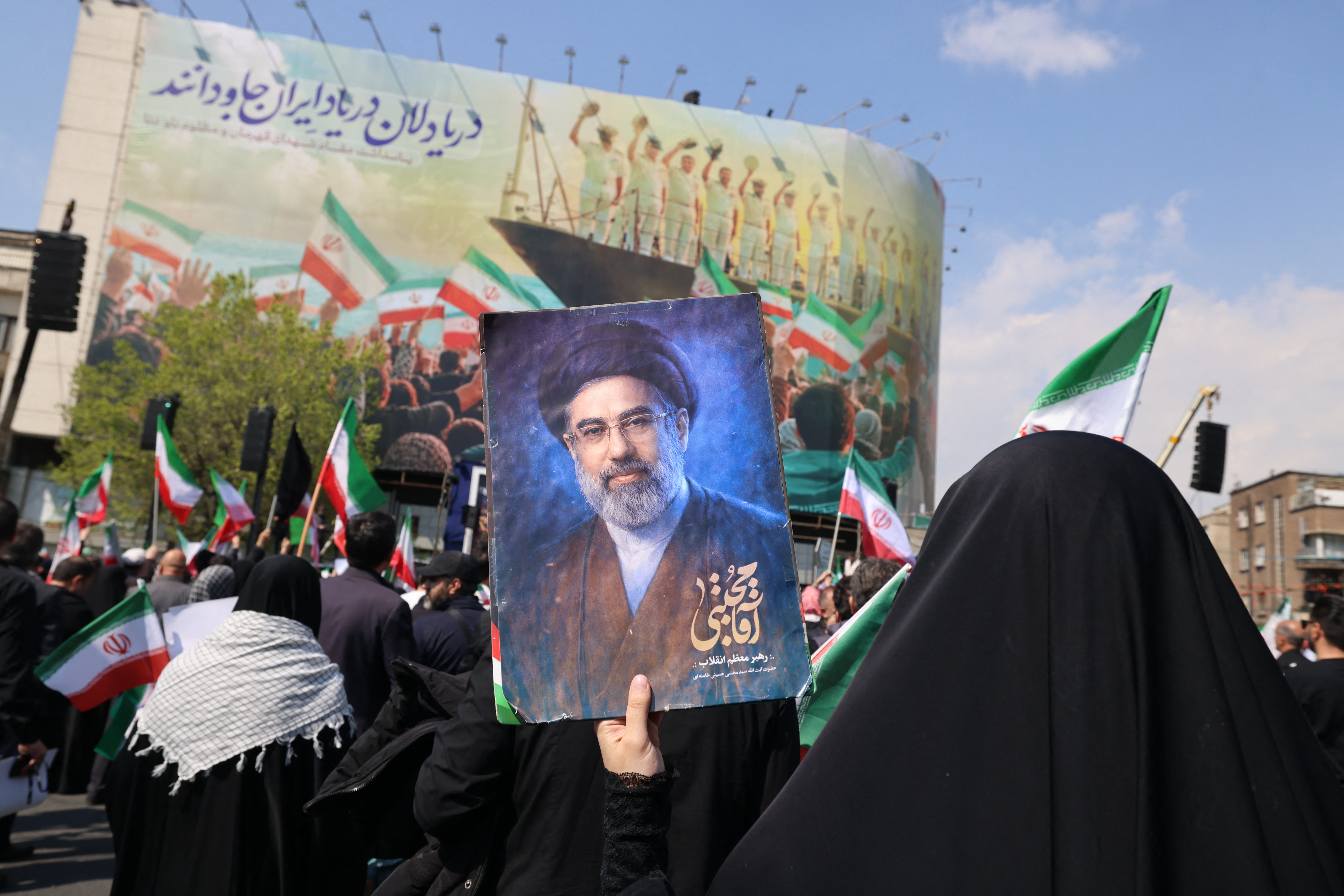 A mourner holds a picture depicting Iran's supreme leader Mojtaba Khamenei during the funeral of Iran's security chief Ali Larijani and Gholamreza Soleimani, a senior officer in the Islamic Revolutionary Guard Corps who commands Basij forces, in Tehran on March 18, 2026.