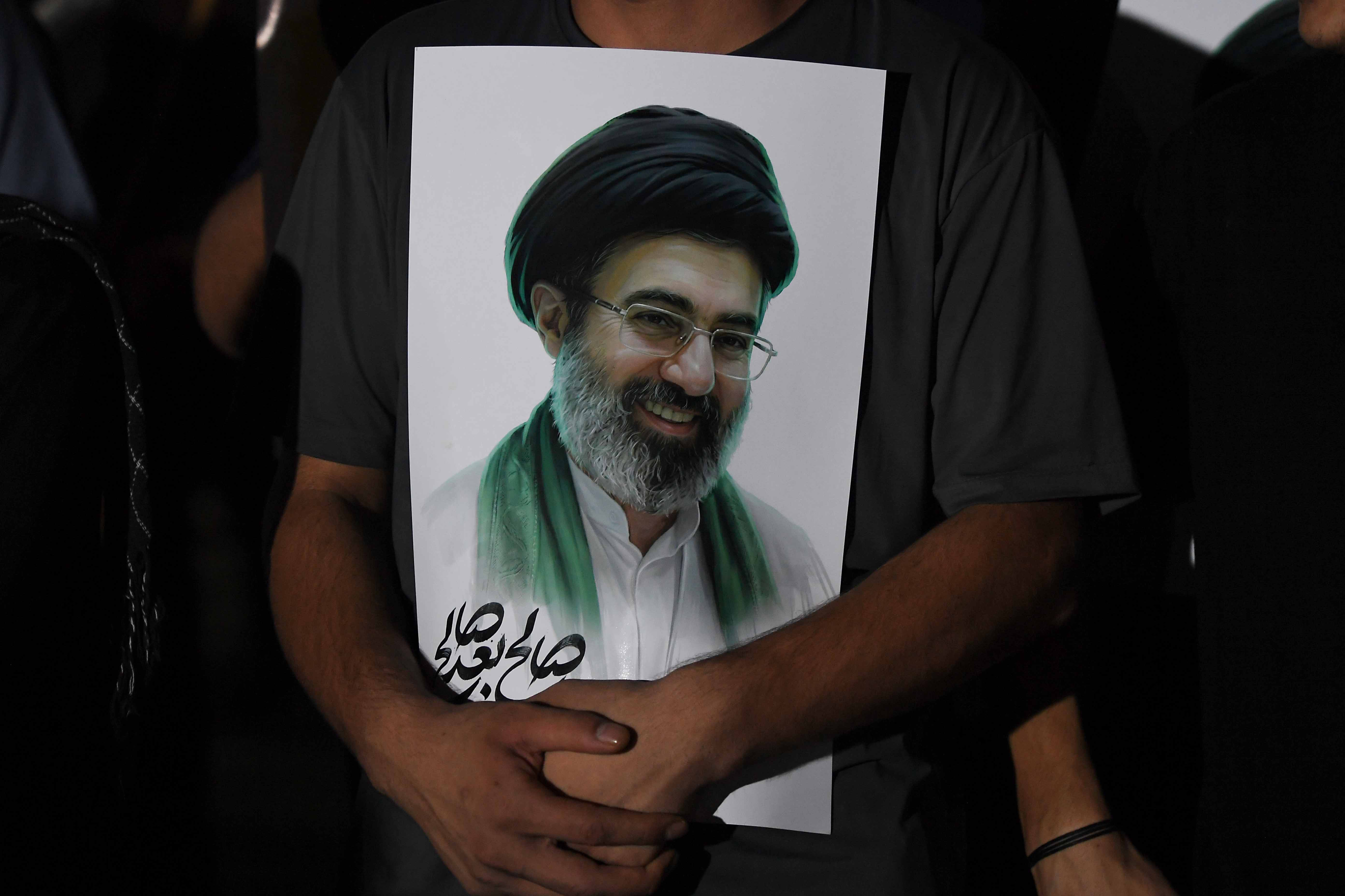epa12830909 A Pakistani Shiite Muslim holds a portrait of Iranian Supreme Leader Ayatollah Mojtaba Khamenei during a demonstration against US-Israeli attacks on Iran, in Karachi, Pakistan, 18 March 2026. Iranian state media confirmed on 01 March 2026 that Iranian Supreme Leader Ayatollah Ali Khamenei was killed in an airstrike during a joint US-Israeli military campaign that began on 28 February 2026. EPA/SHAHZAIB AKBER