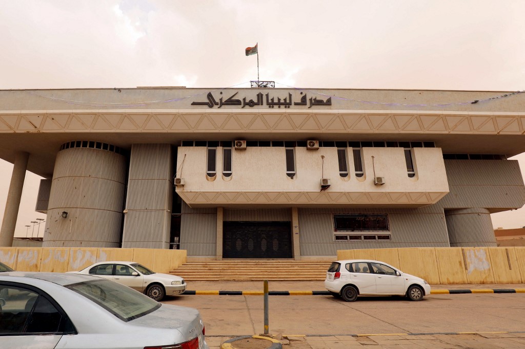 Cars parked in front of a branch of Libya's Central Bank.