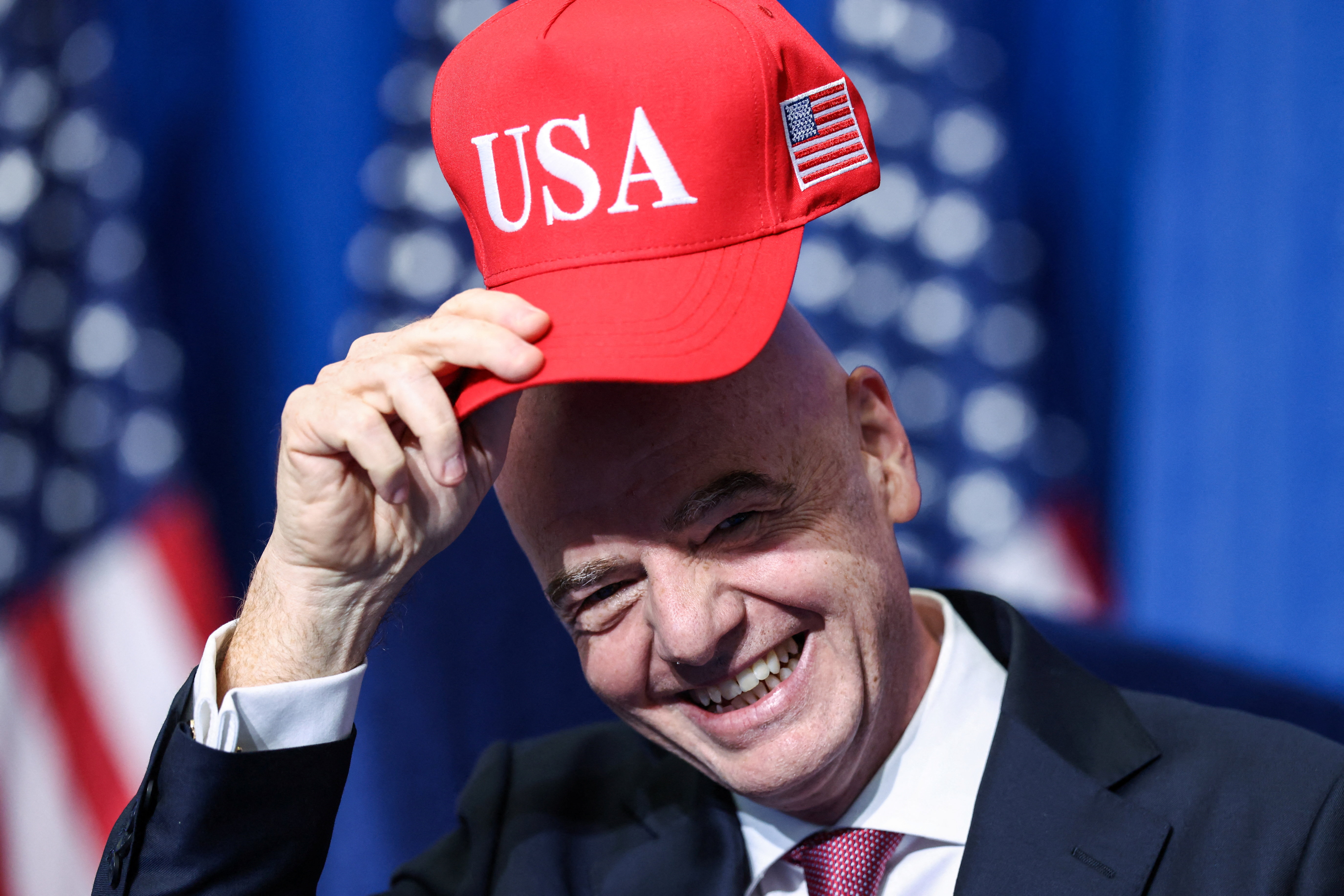 FIFA president Gianni Infantino holds a USA hat.