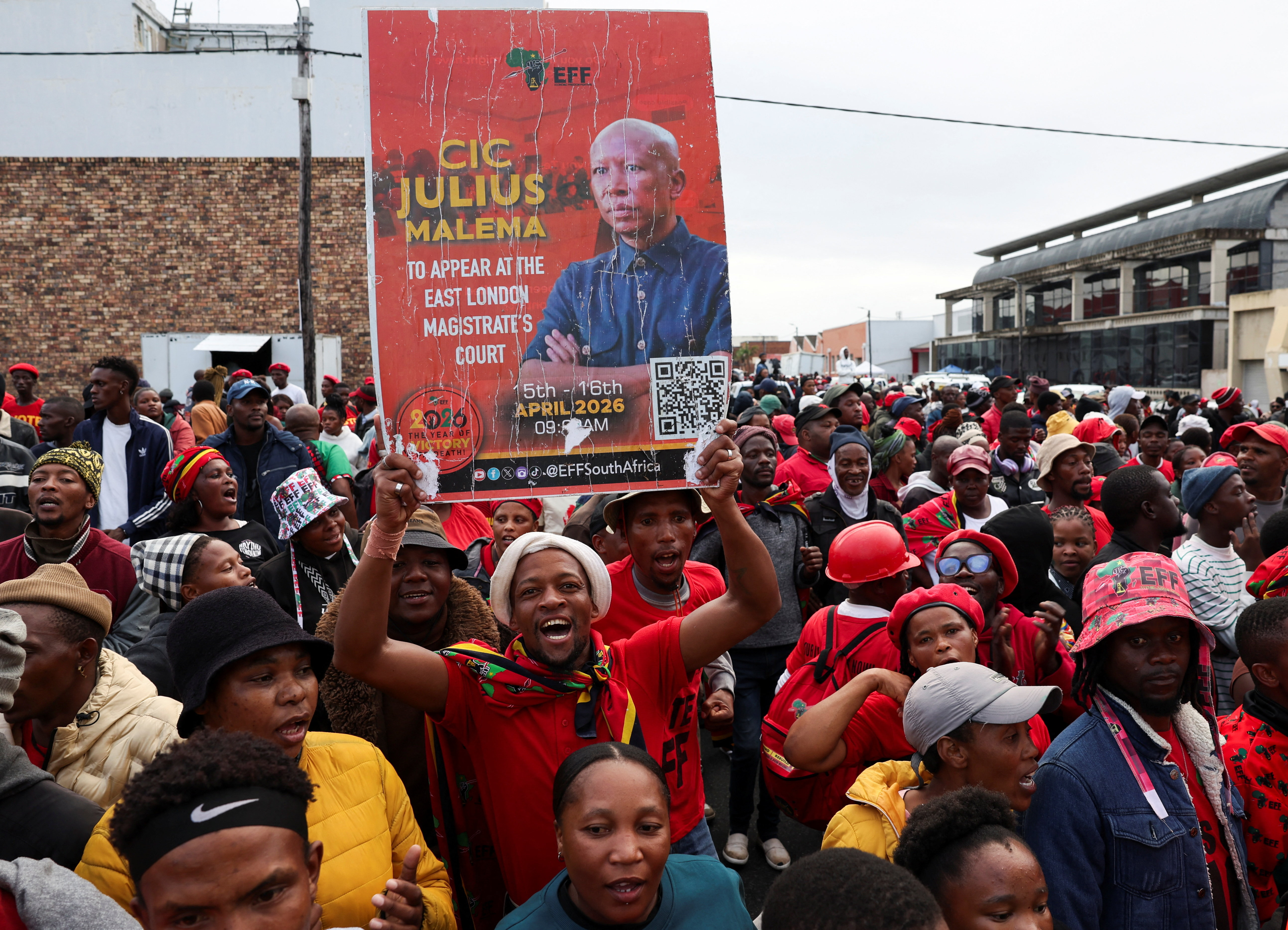 An Economic Freedom Fighters (EFF) supporter holds up a placard as supporters gather outside court ahead of South African opposition politician Julius Malema’s appearance for sentencing after being convicted of charges including unlawful possession of a firearm and discharging a weapon in public, in KuGompo City, South Africa, April 16, 2026.