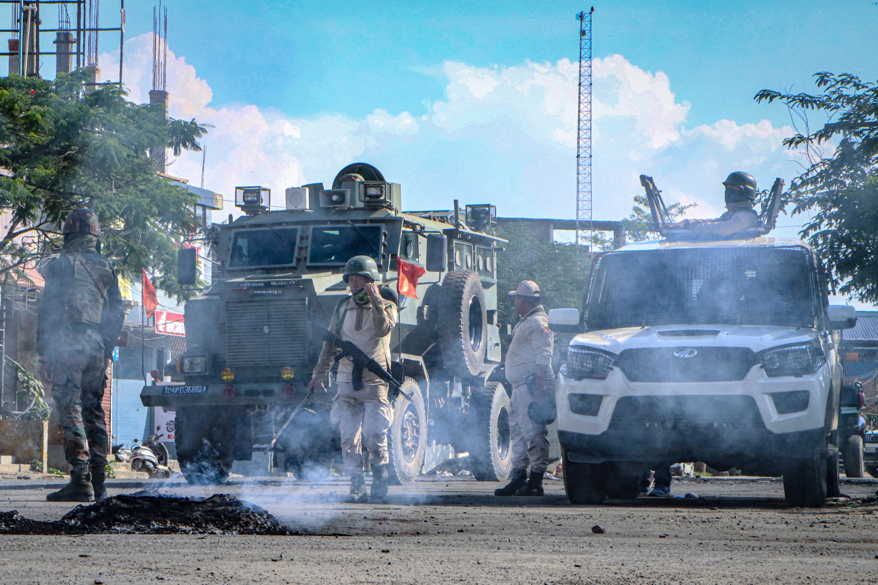 Security vehicles are positioned in the middle of a road.