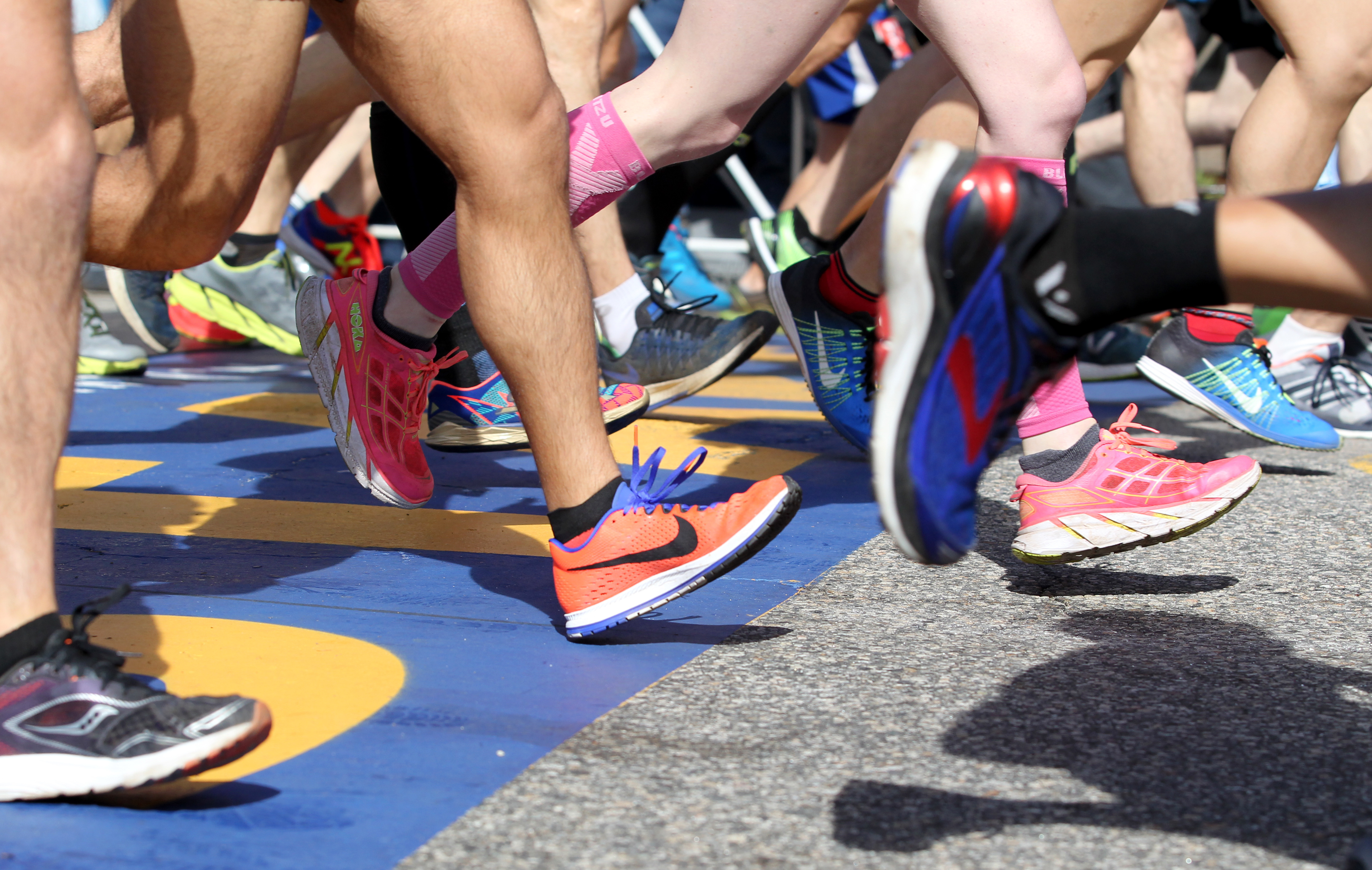 A colorful collection of shoes cross the starting line at the start of the 2017 Boston Marathon