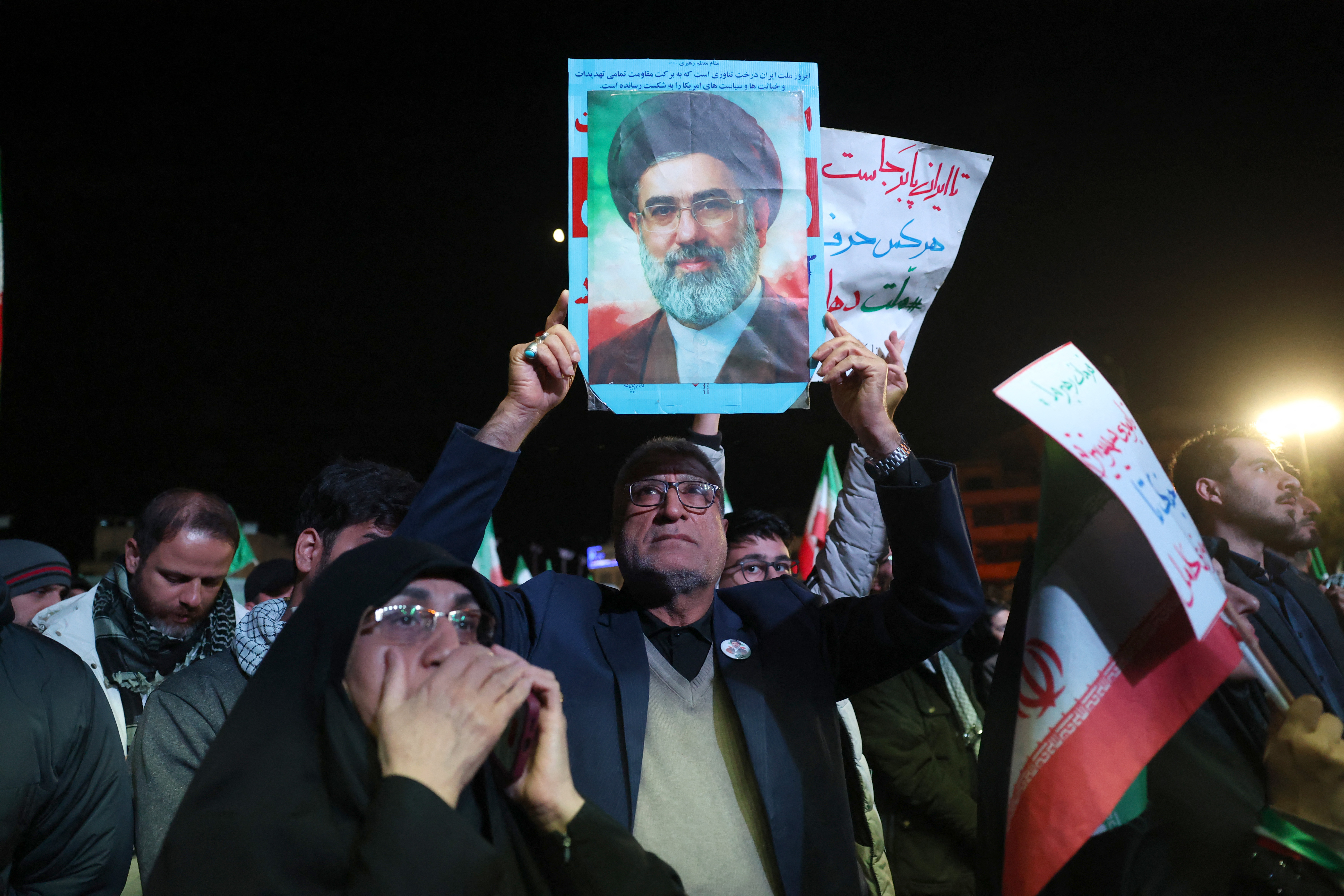 An Iranian man holds up picture of Iranian supreme leader Ayatollah Mojataba Khamenei as others react to a ceasefire announcement at the Enqelab square, in Tehran, on April 8 2026.