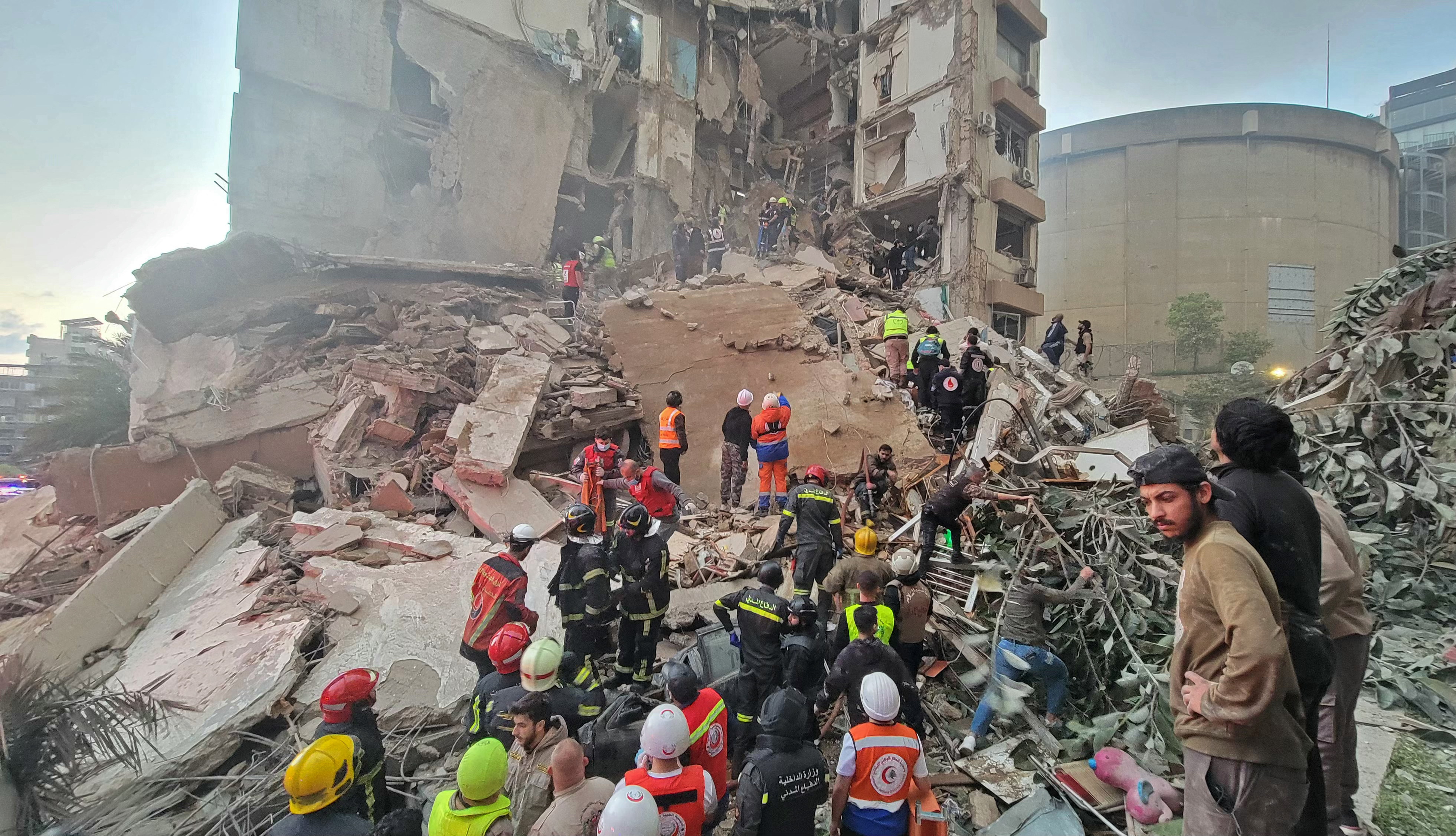 First responders and residents gather at the site of destruction following an attack.