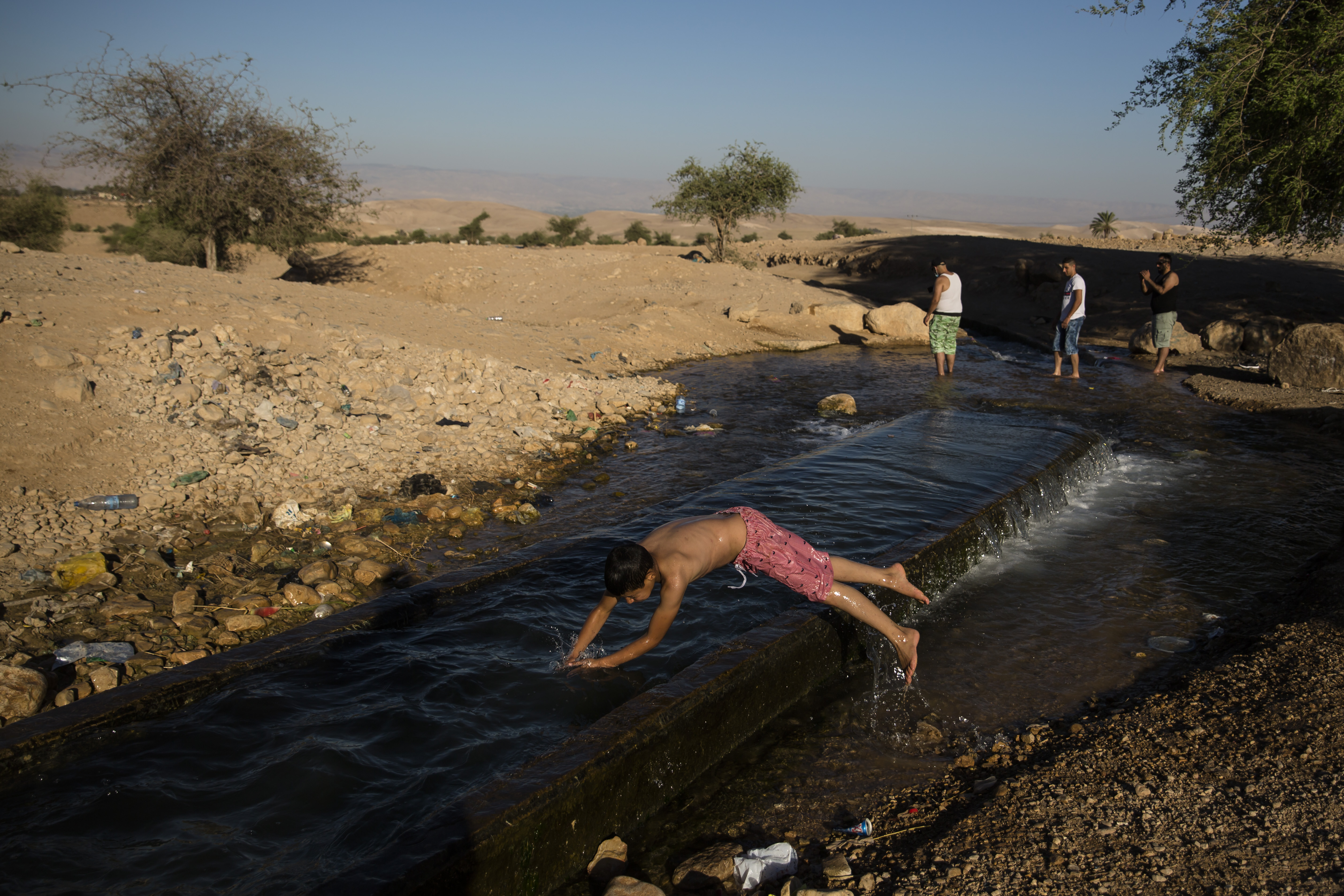 EIN AL-AUJA, ISRAEL - JUNE 24: A Palestinian boy jumps in the water of the natural spring of EIn AL-Auja on June 24, 2020 in Ein Al-Auja, West Bank. Israeli Prime Minister Benjamin Netanyahu's plan, which has drawn international reproval, would entail applying Israeli sovereignty to parts of the West Bank including Jewish settlements, as well as most of the Jordan Valley. (Photo by Amir Levy/Getty Images)