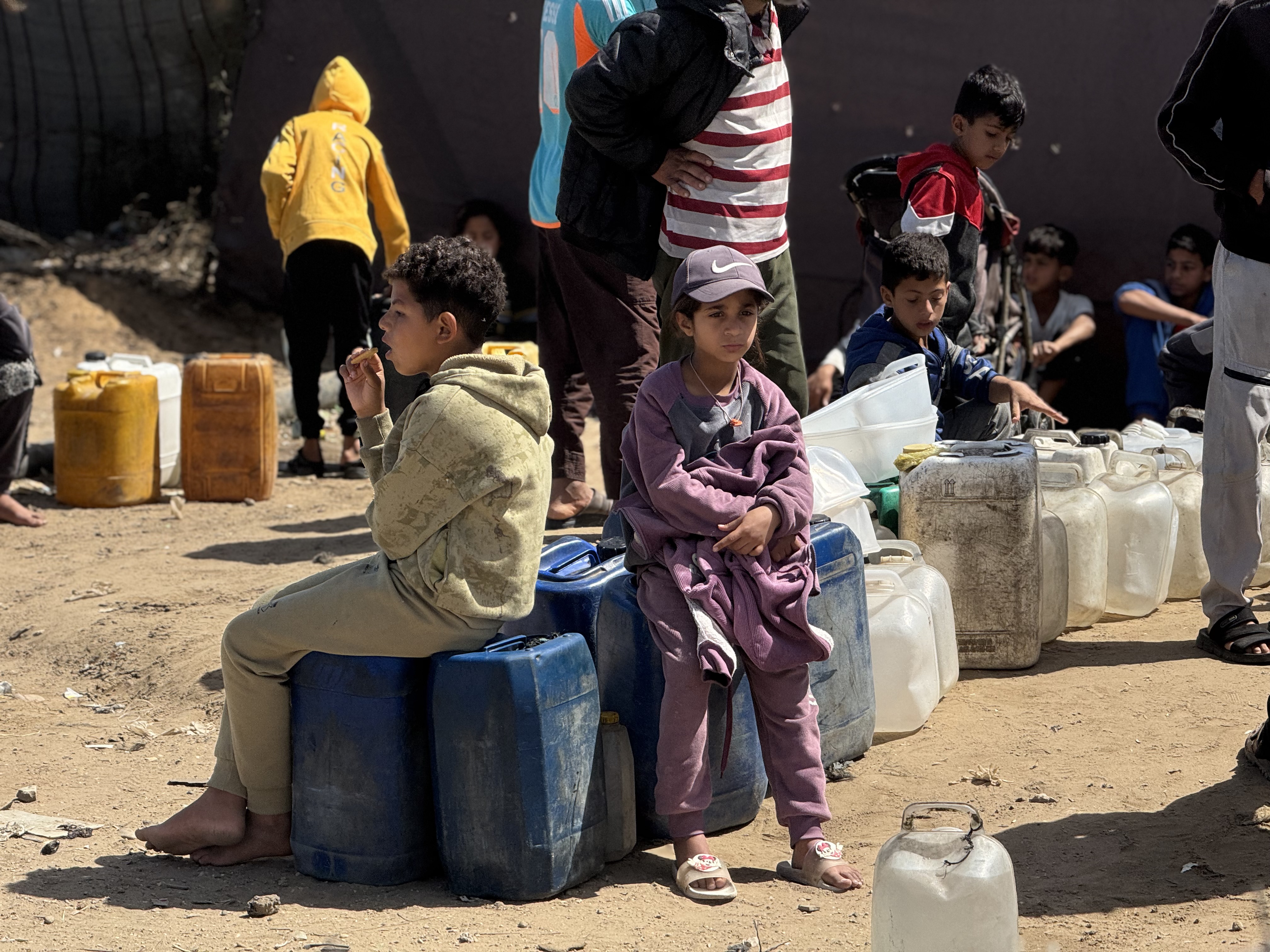 Children wait to fill water