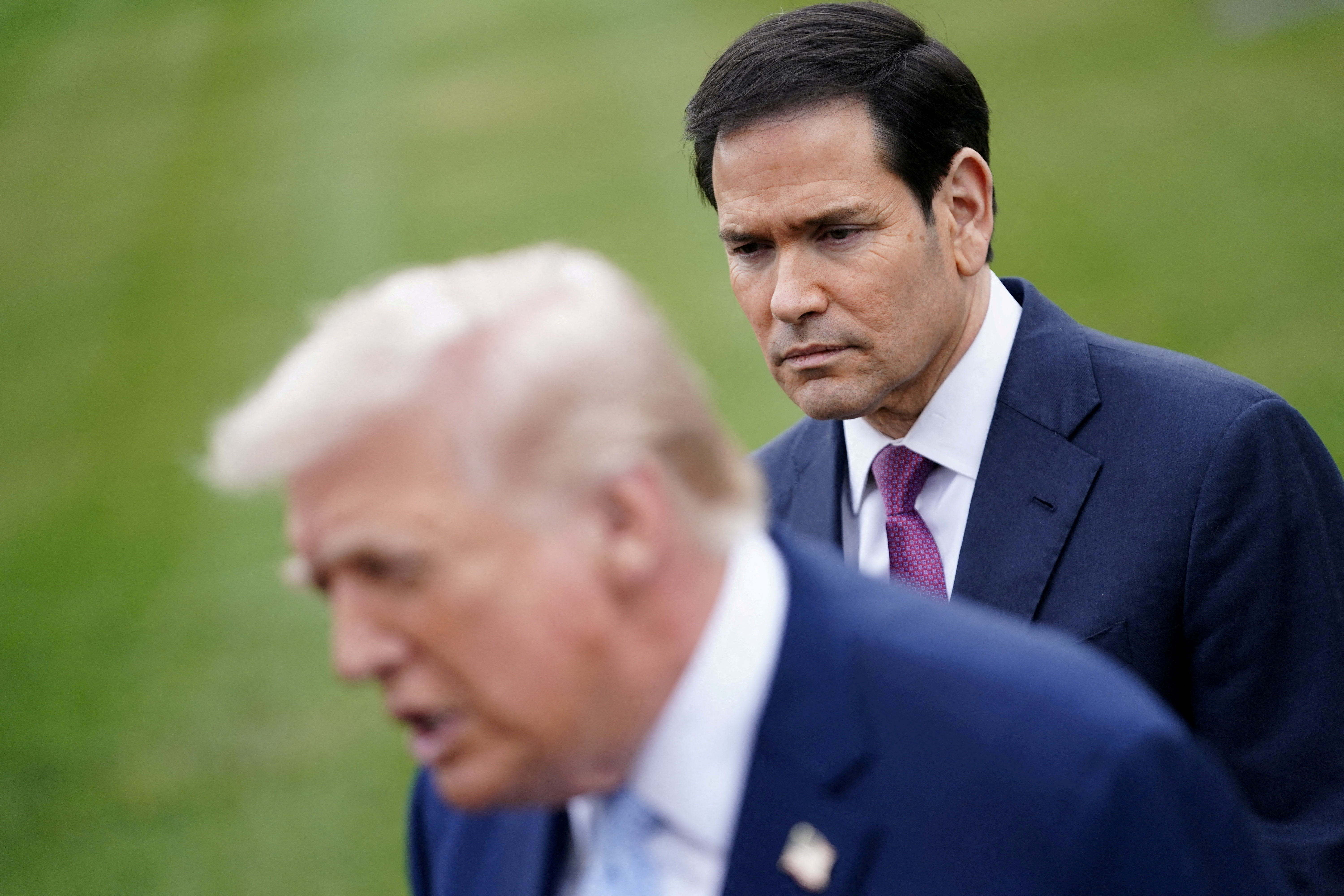FILE PHOTO: U.S. Secretary of State Marco Rubio listens to U.S. President Donald Trump speaking to the media, as Trump departs the White House for Florida, in Washington, D.C., U.S., March 20, 2026. REUTERS/Nathan Howard/File Photo