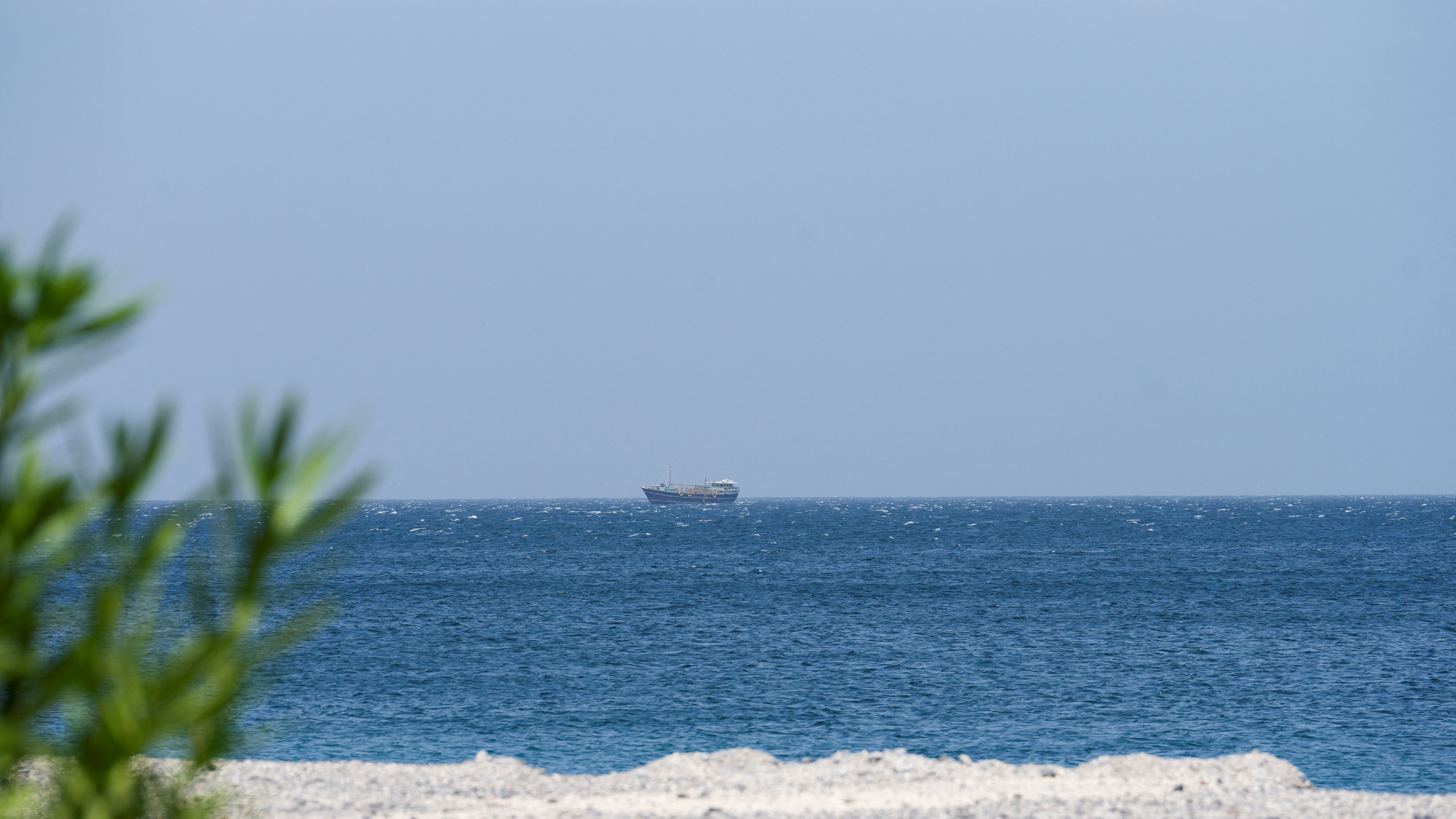 FILE PHOTO: A boat is off the coast of Musandam governorate, overlooking the strait of Hormuz, in Musandam governance, in Oman, April 8, 2026.REUTERS/Stringer/File Photo