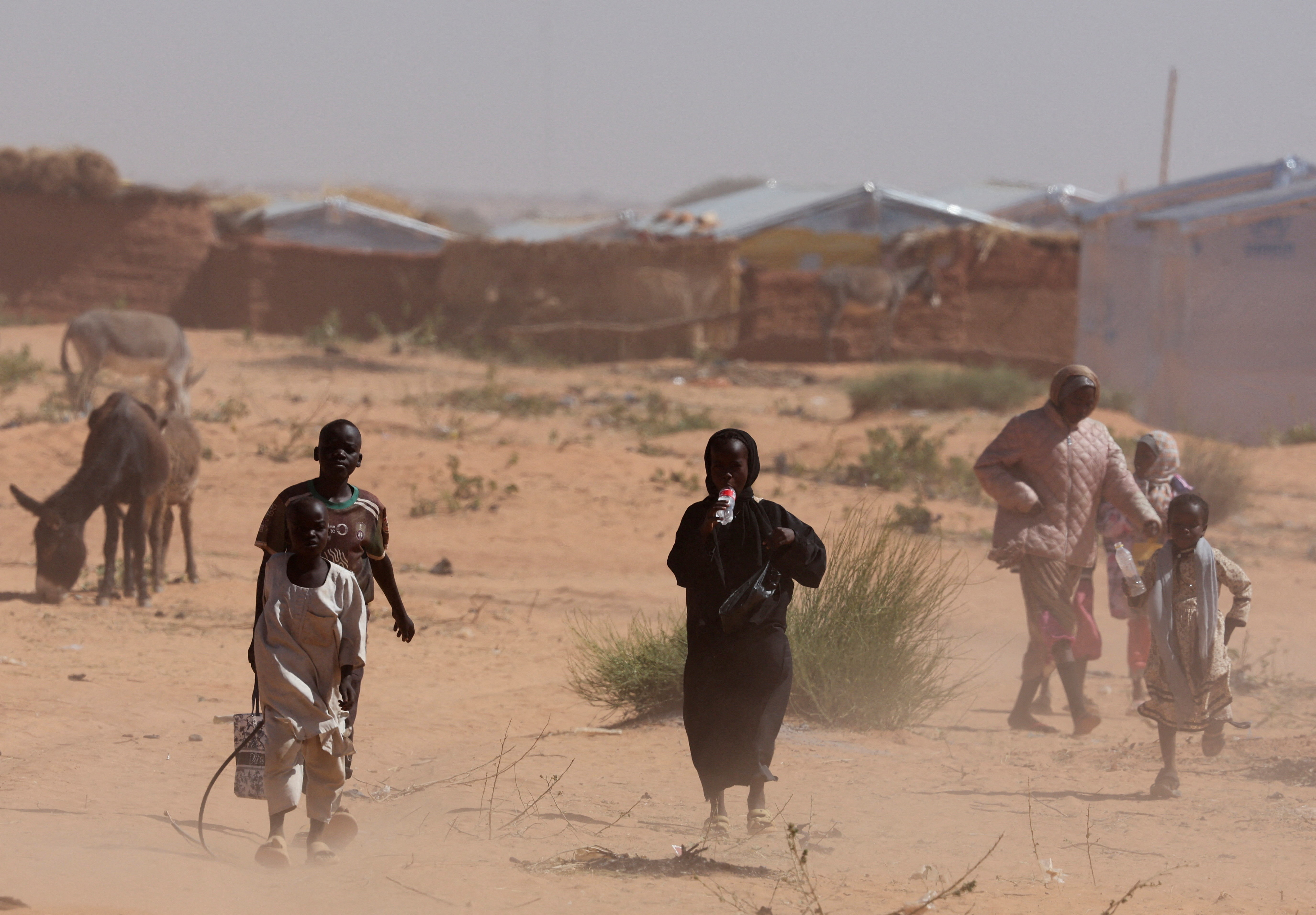 FILE PHOTO: Sudanese refugees from Darfur walk amidst a sandstorm at the Touloum refugee camp, amid ongoing conflict in their country, on the outskirts of the town of Iriba in Wadi Fira province, eastern Chad, November 30, 2025. REUTERS/Amr Abdallah Dalsh/File Photo
