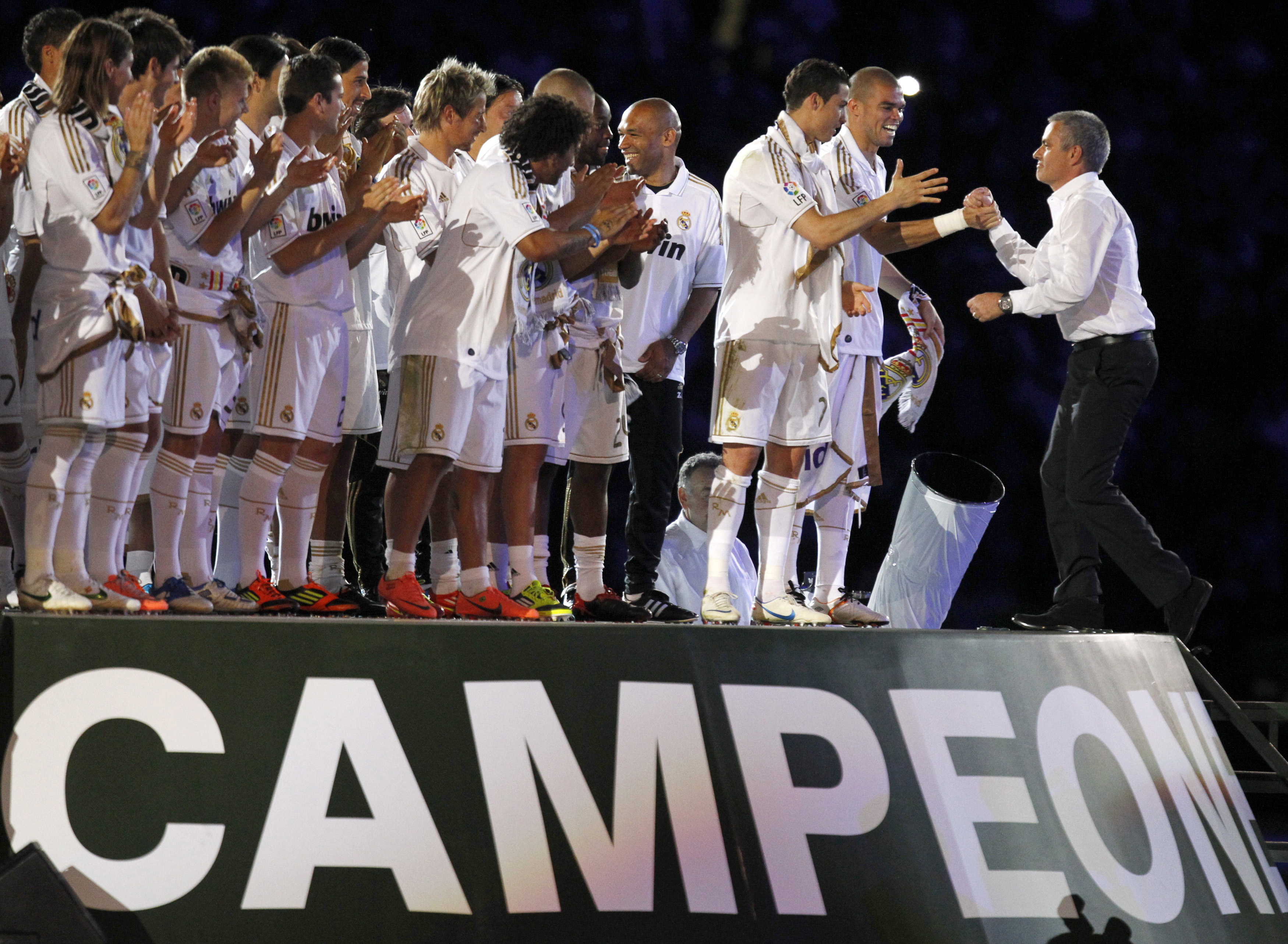 Real Madrid's coach Jose Mourinho (R) shakes hands with Pepe and Cristiano Ronaldo as they celebrate their Spanish league first division 32nd title at Santiago Bernabeu 