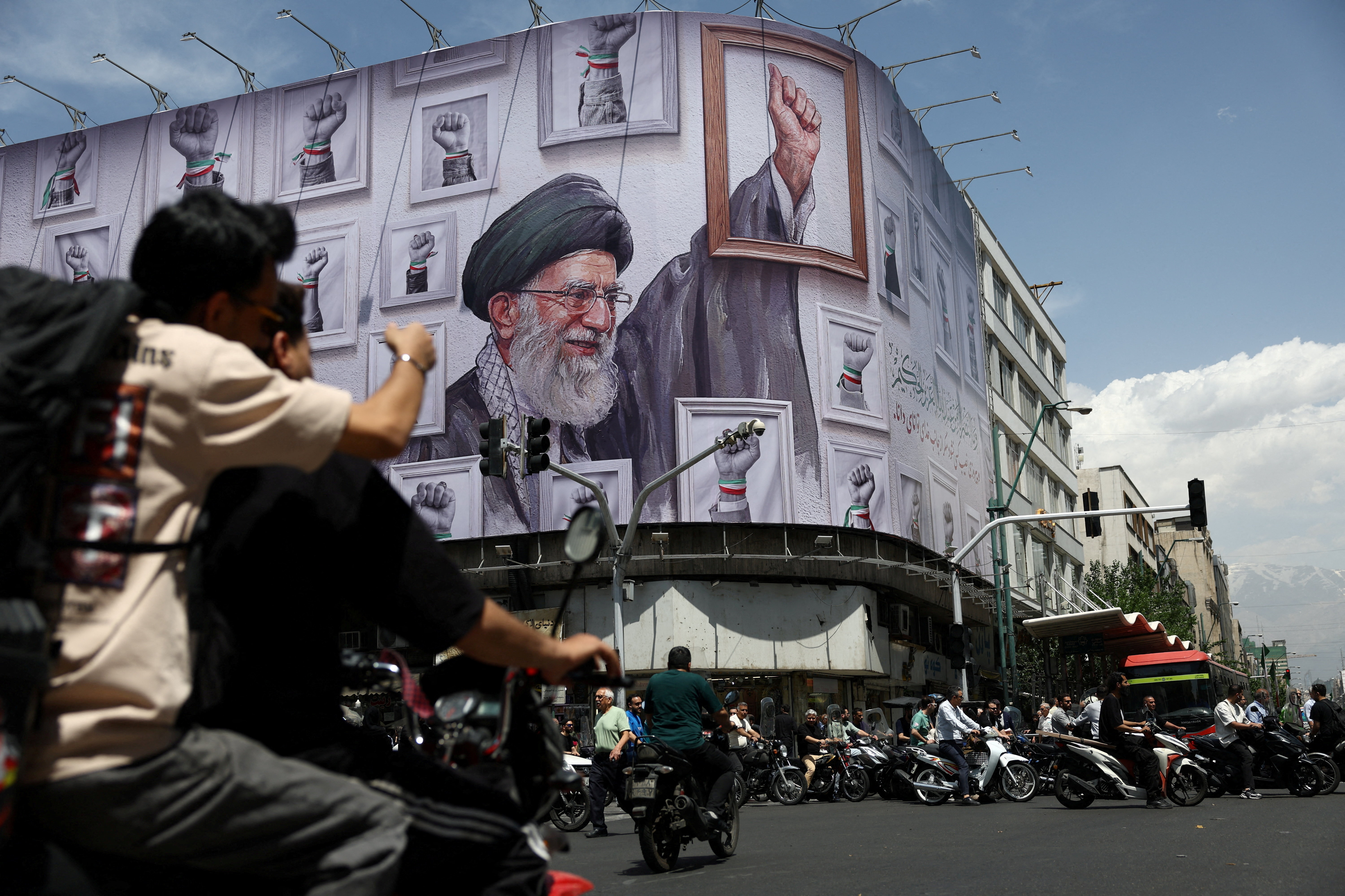 People ride motorcycles near a billboard featuring an image of the late Supreme Leader of Iran, Ayatollah Ali Khamenei, in Tehran, Iran, May 6, 2026. Majid Asgaripour/WANA (West Asia News Agency) via REUTERS ATTENTION EDITORS - THIS PICTURE WAS PROVIDED BY A THIRD PARTY TPX IMAGES OF THE DAY